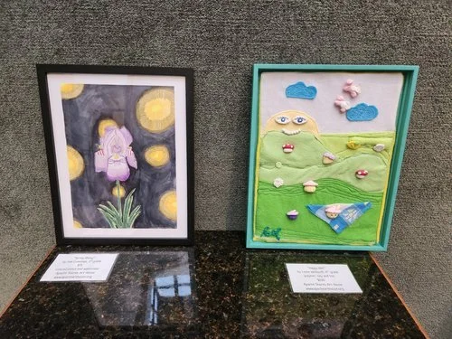 Colorful student portraits and mixed-media artwork displayed on a gallery wall