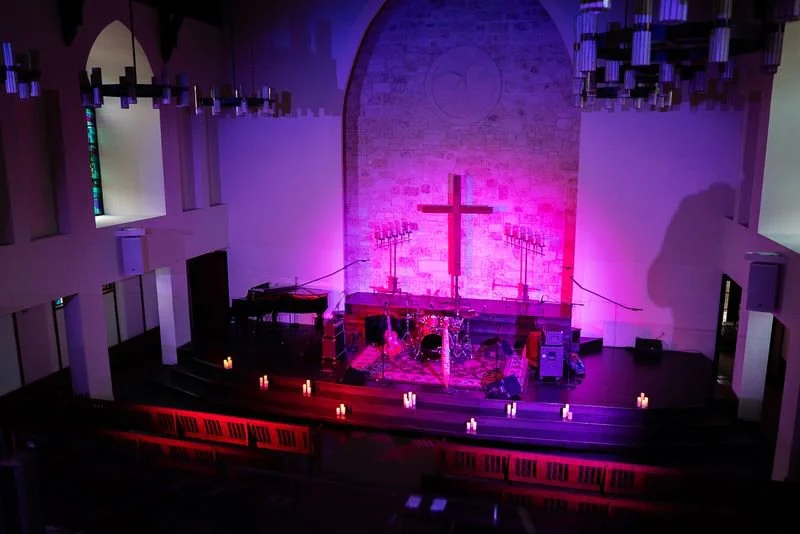 Riverbend Centre auditorium and stage illuminated with purple lighting