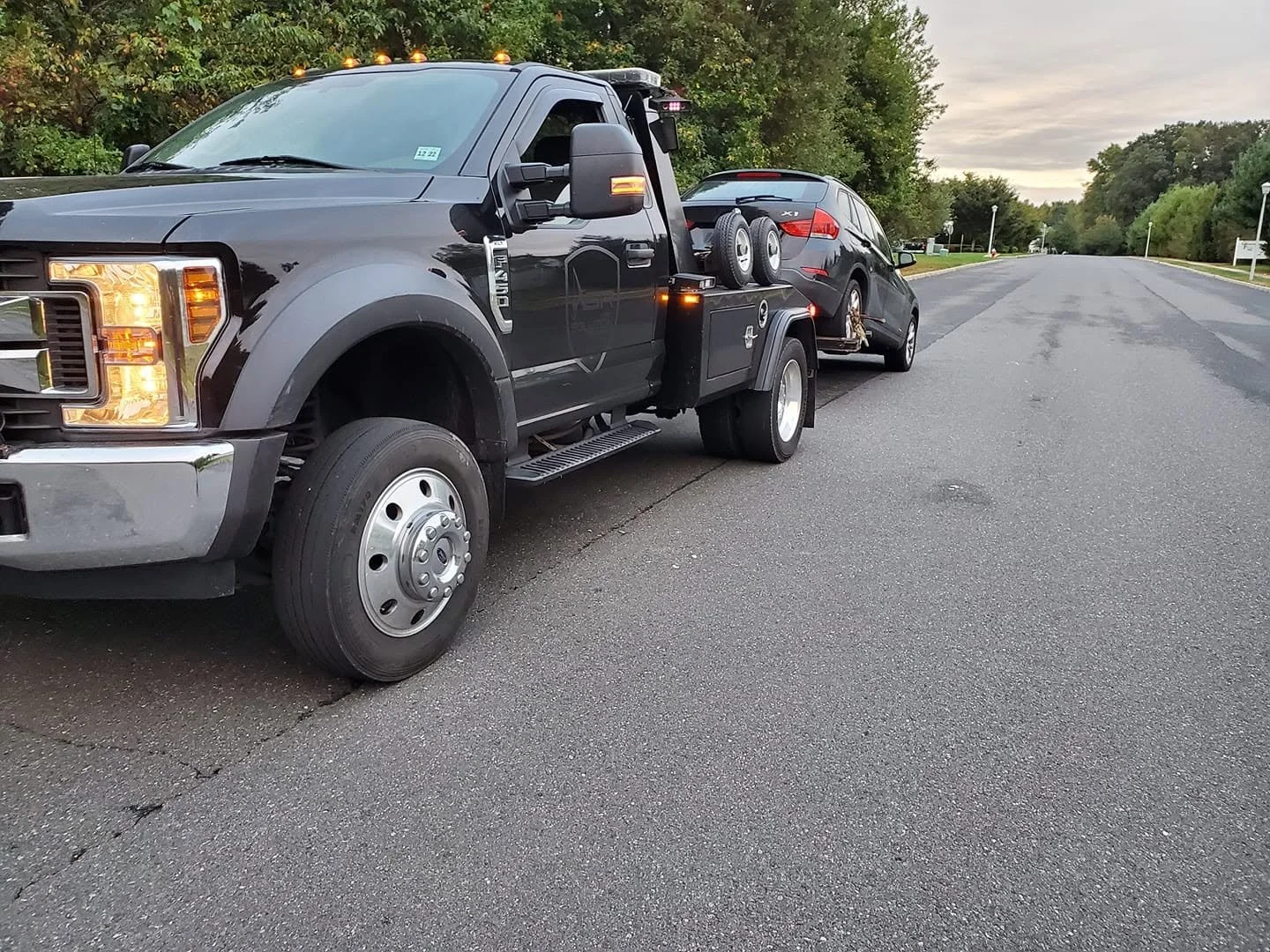 Recovery truck hauling a vehicle for Jaclyn's former repossession company