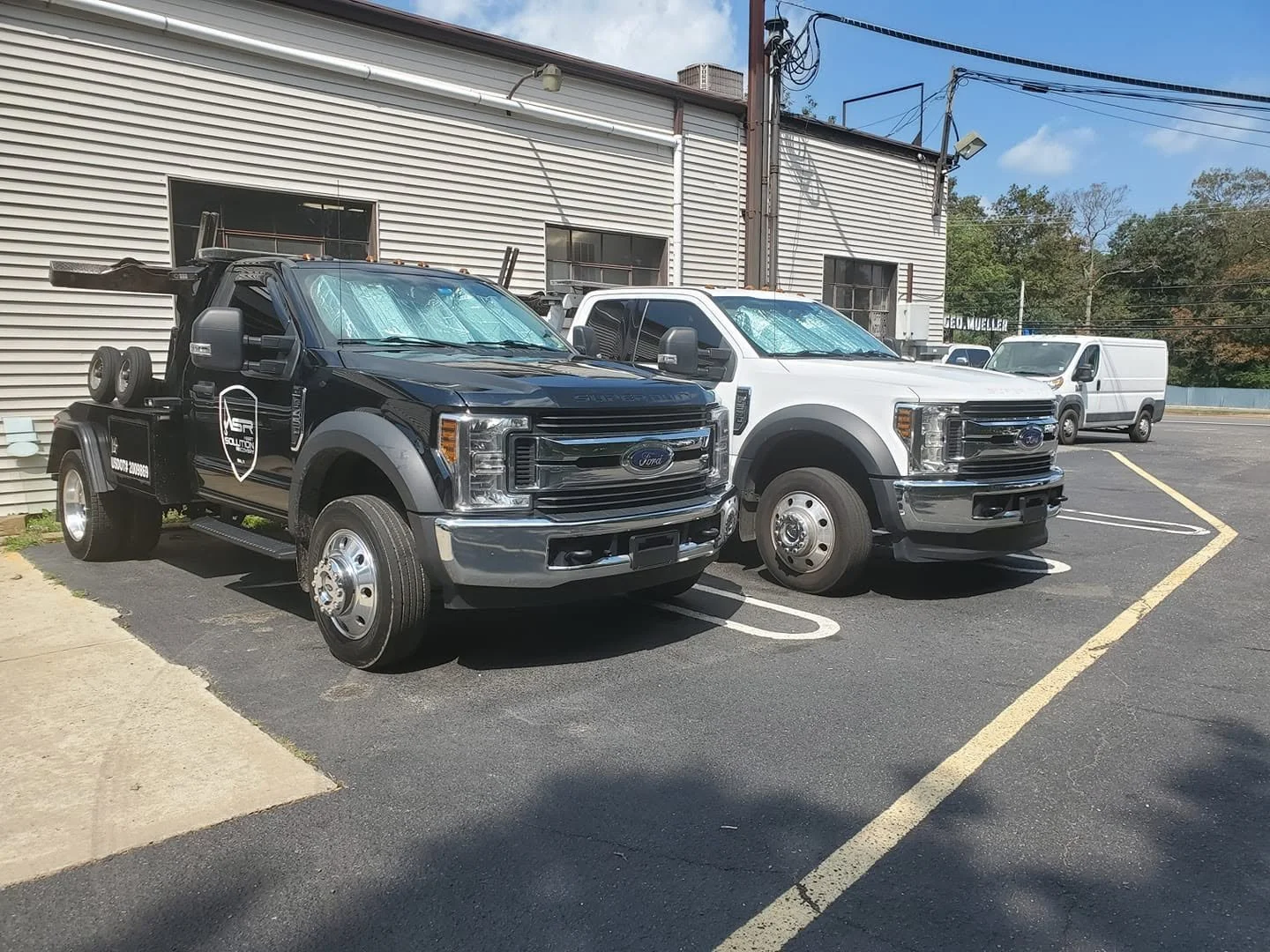 Two recovery trucks from Jaclyn's former repossession and transport company