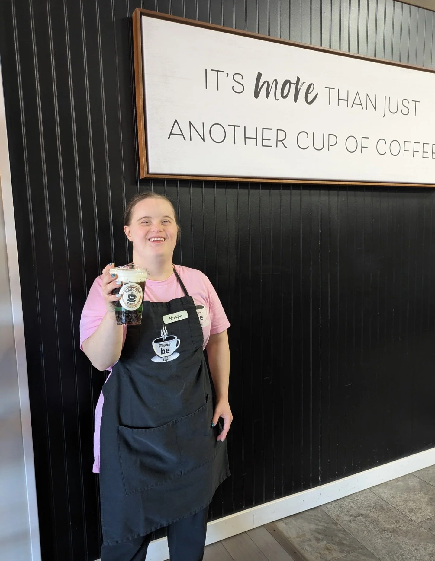 Maggie holding coffee at Maggie's Place