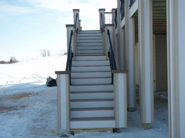Outdoor staircase leading to the second floor of a building, with snow on the ground.