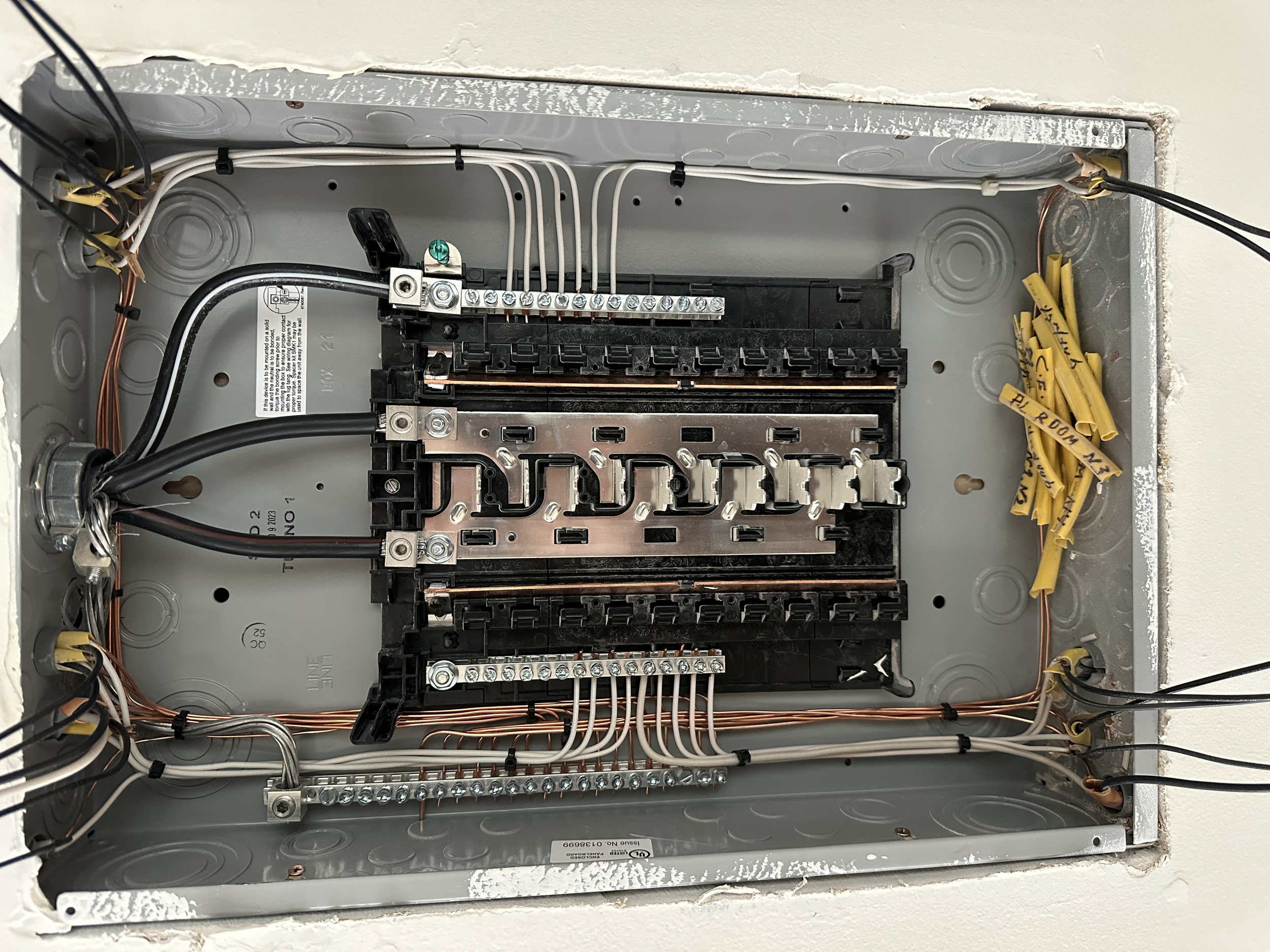 Electrical wiring inside an open electrical box with black, white, and copper wires connected to various terminals and screws.