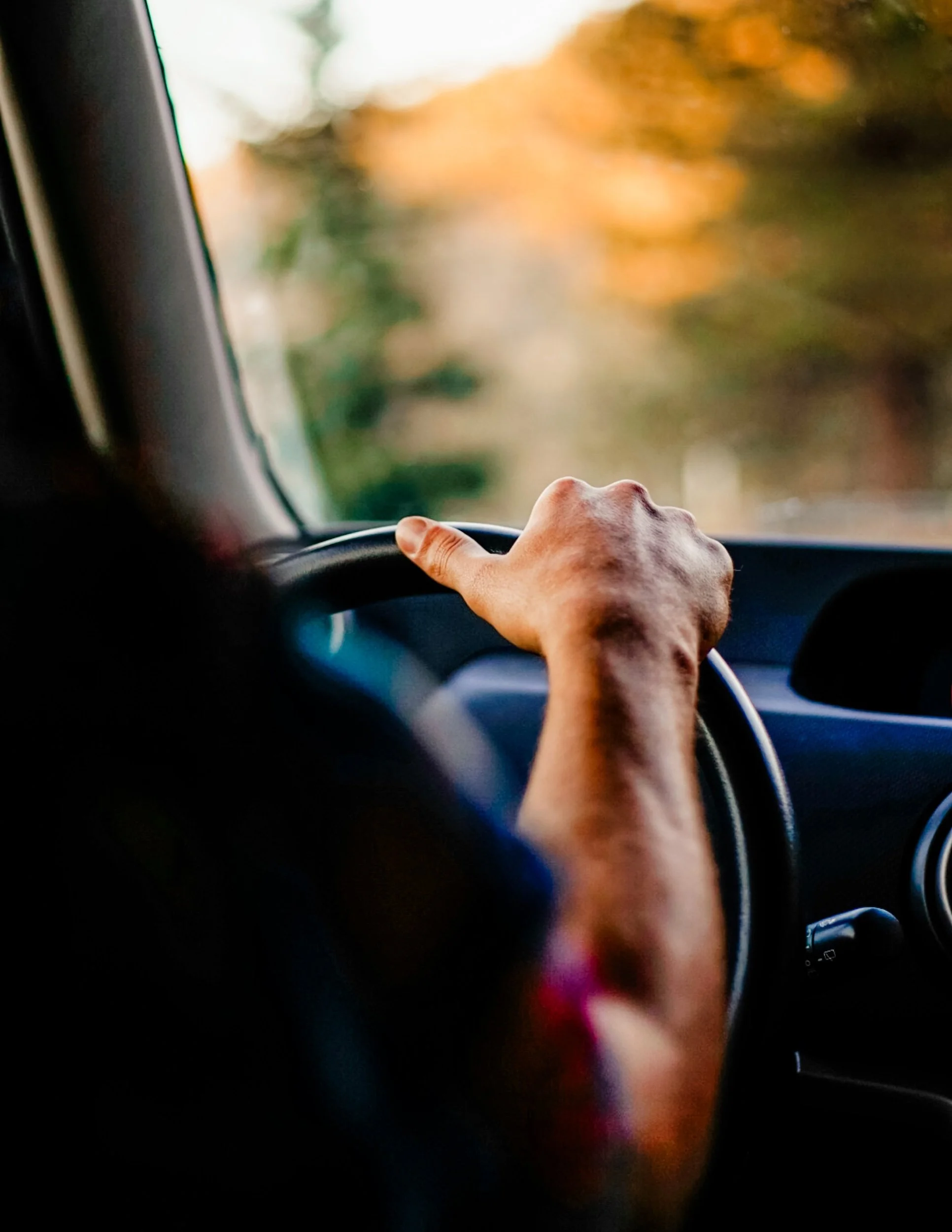 Photo of a Courier Driver's Hands Safely and Attentively Steering a Delivery Van Down a Road