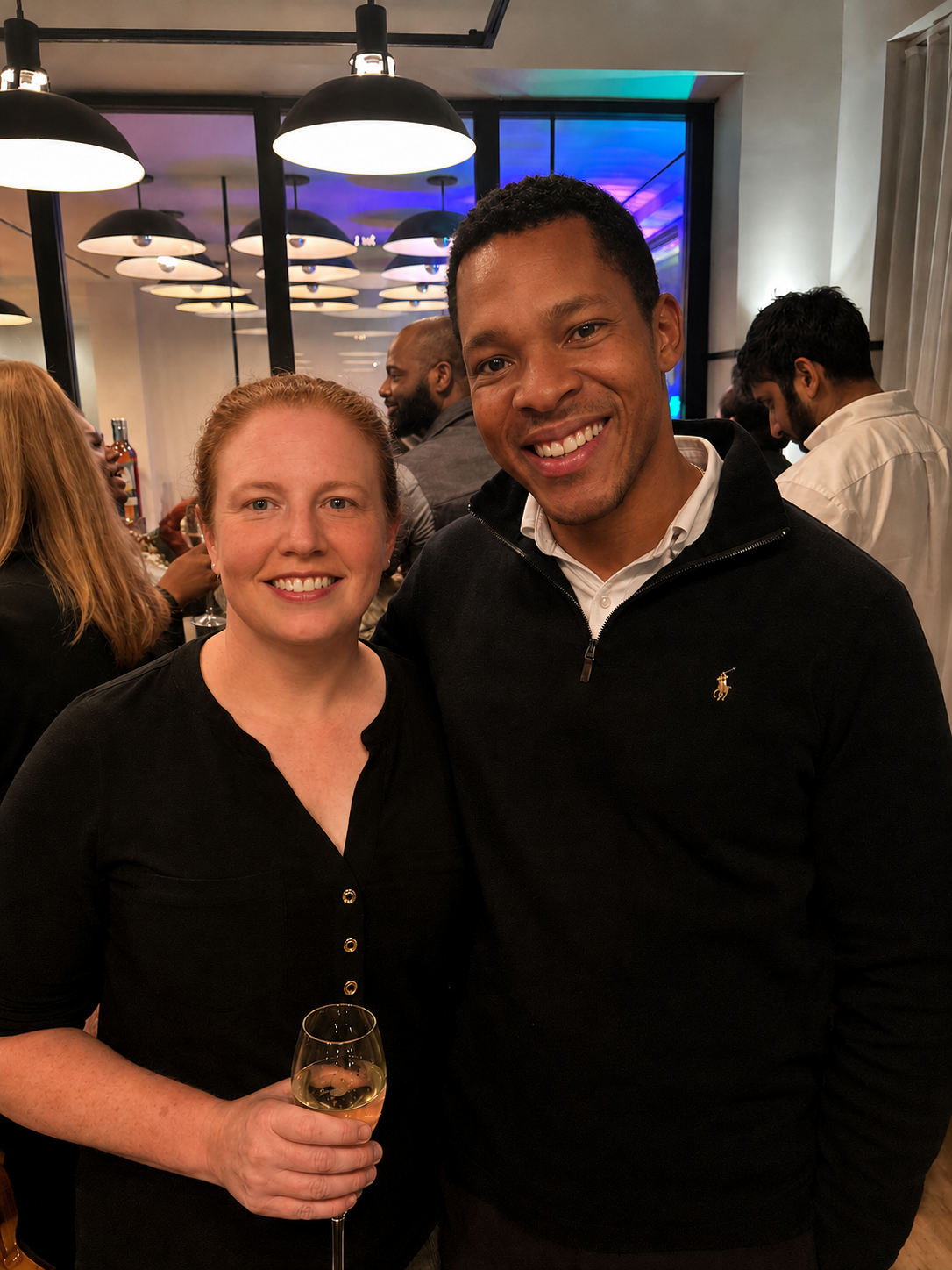 Executive Coach and Washington Urban Debate League Board Member Allison Pickett and Capital One associate Emmanuel Murphy smile at a fundraiser for Washington Urban Debate League.