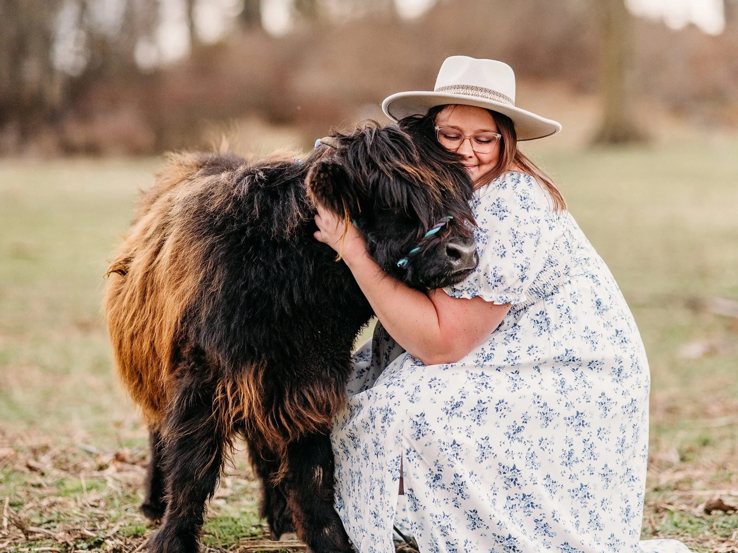 women hugging highland cow