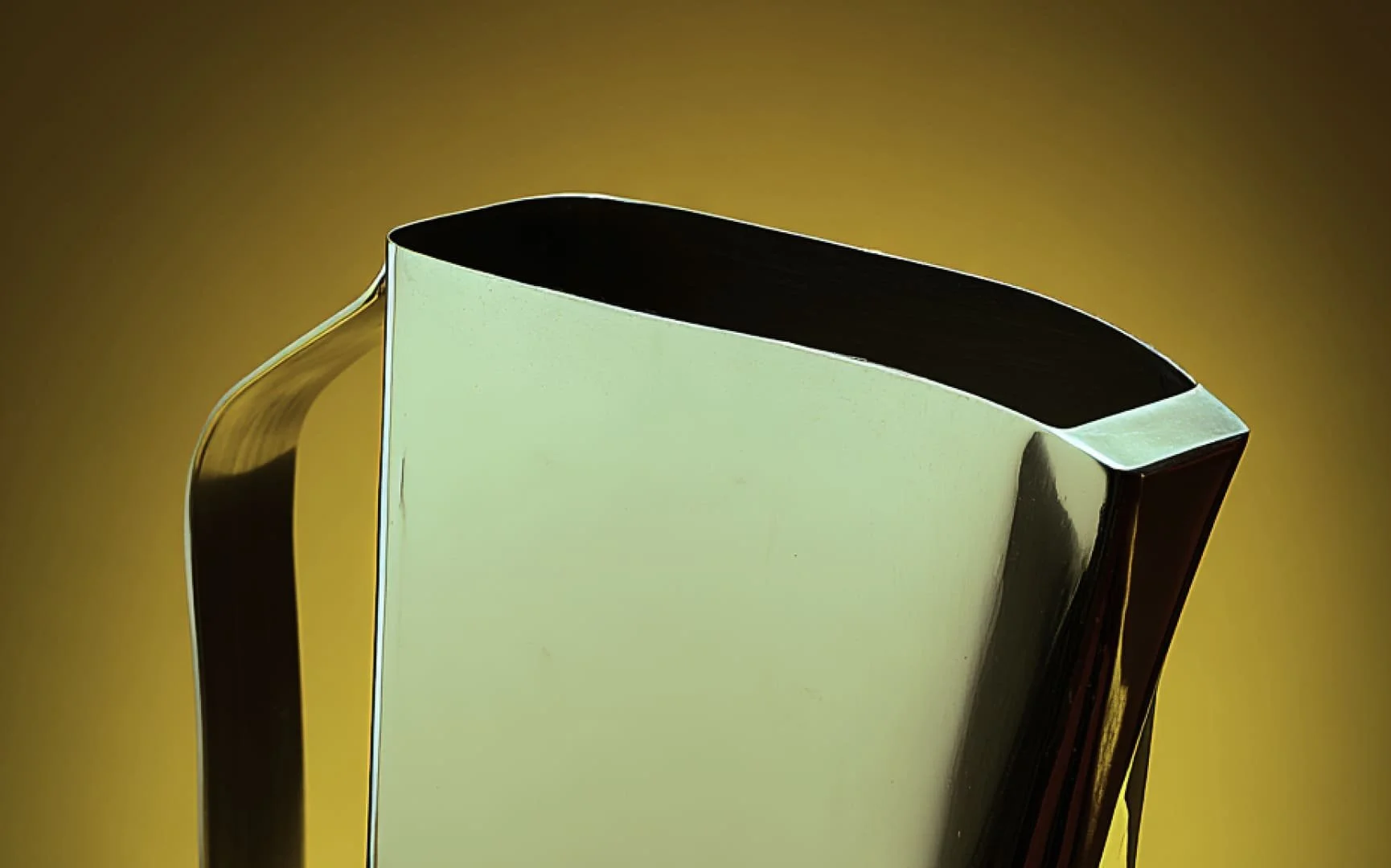 Close-up of a vintage, modern-style, metallic silver and black thermos or travel mug against a plain yellow background.