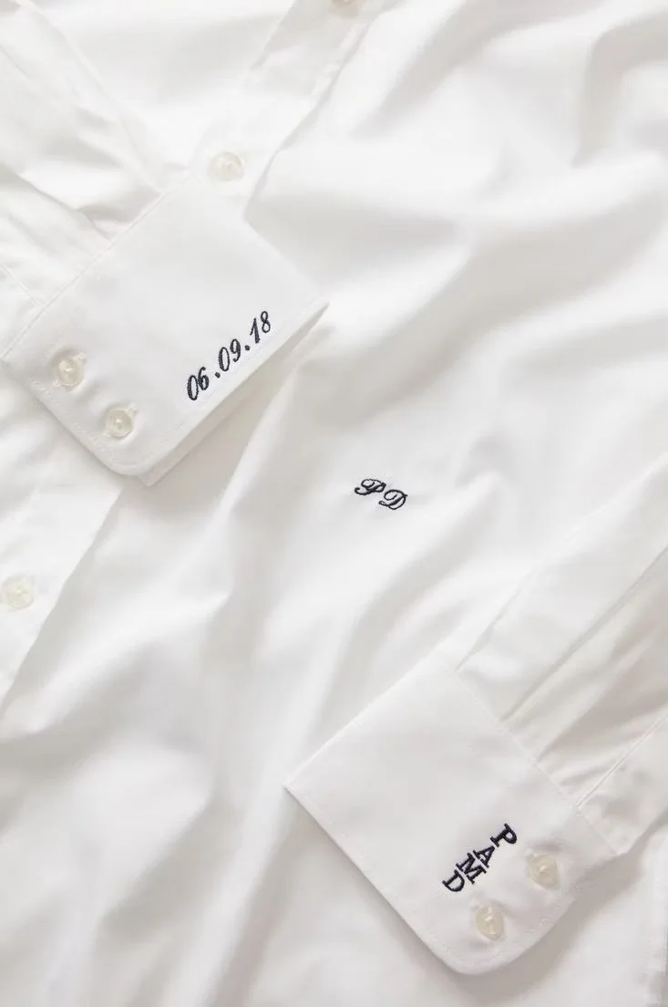 White dress shirt with embroidered initials 'G G' and a date '06.09.18' on the collar and cuffs.