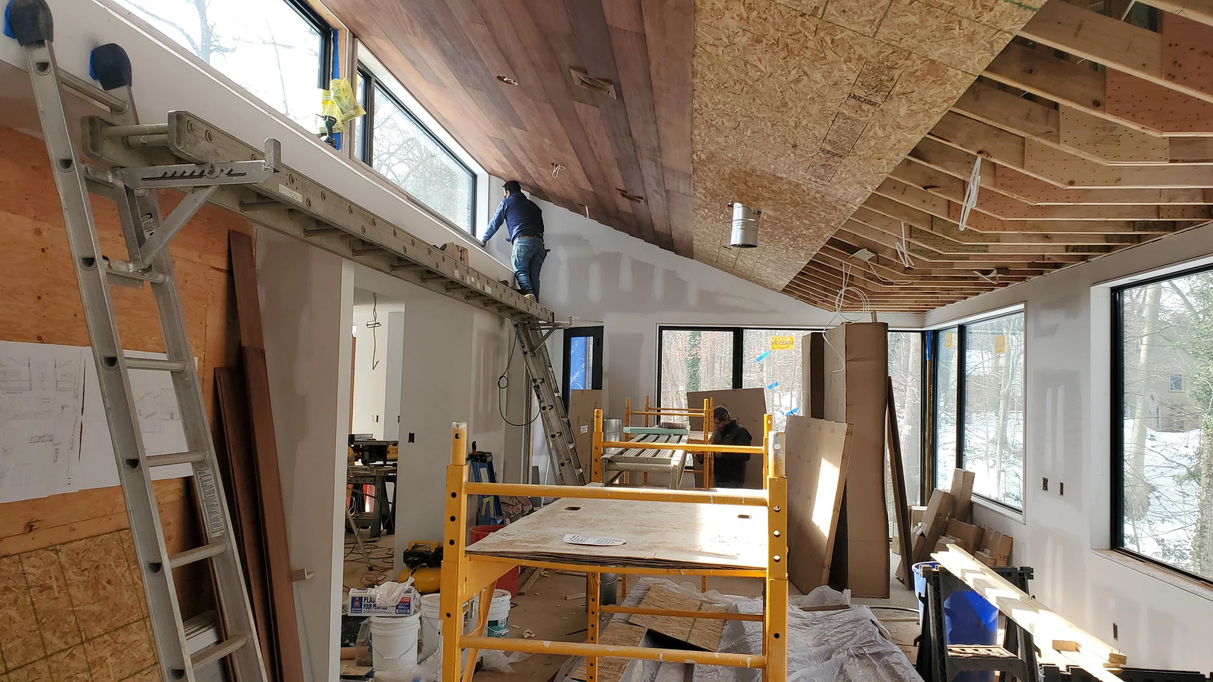 February 2021: the 1948 house comes home. Board by board, the mahogany that was once the siding goes up as the ceiling — the only part of the original house the oil tank couldn't take.