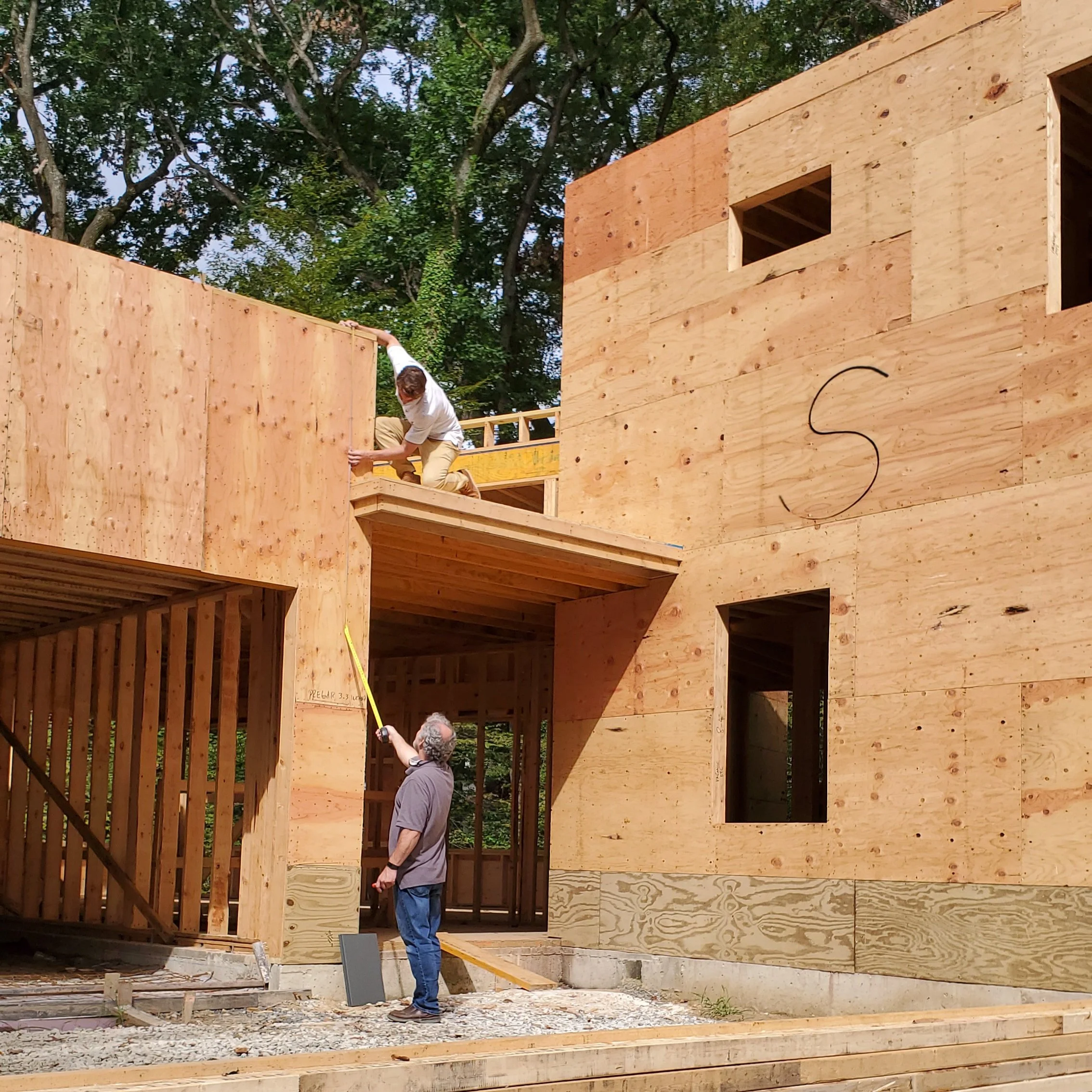 Architect Jay Reinert measuring the entry breezeway of Hadro House in Haddonfield NJ during a construction site visit, September 2020 — construction administration in person