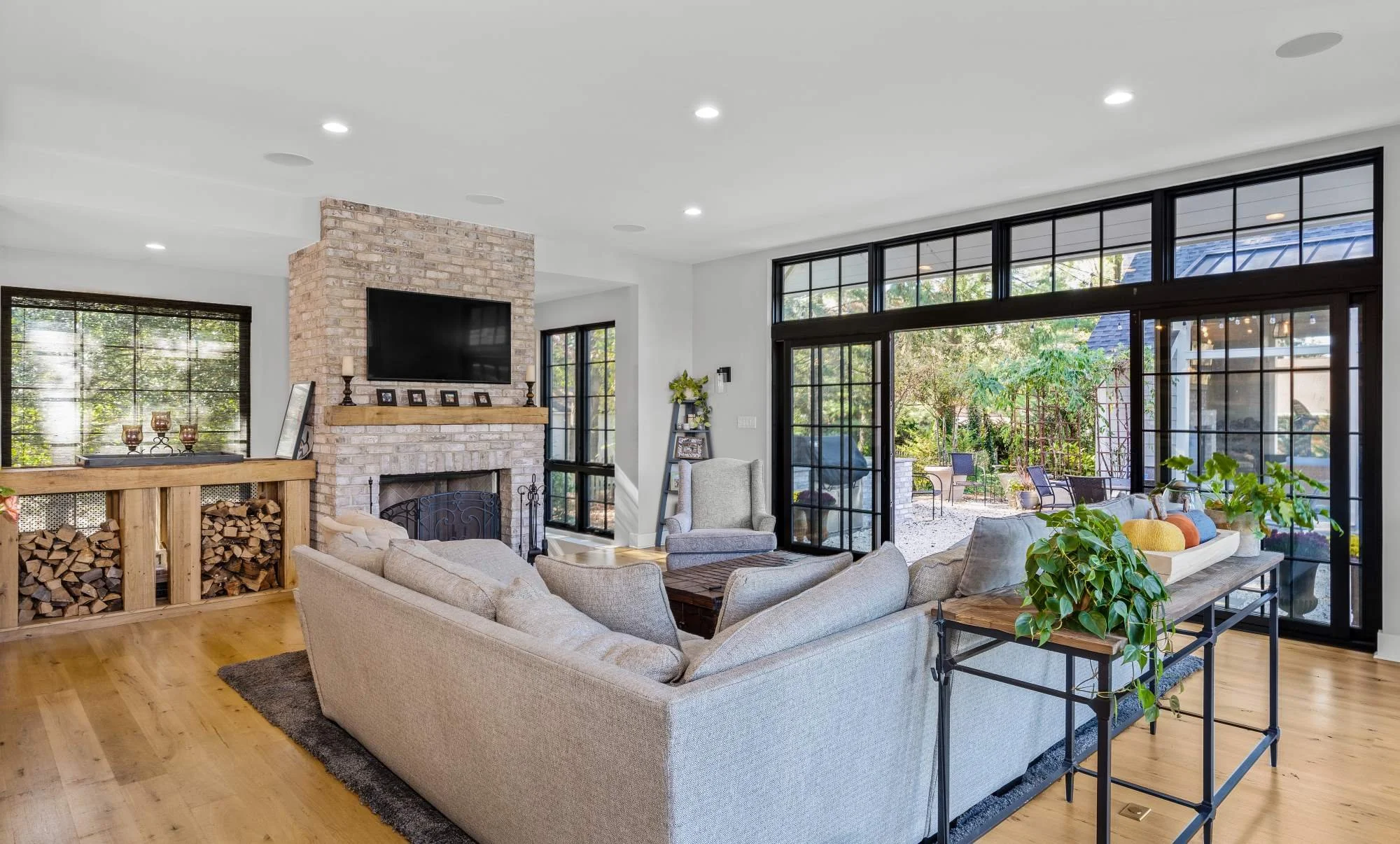 indoor-outdoor-living-kitchen-family-room-floor-to-ceiling-windows-glass-doors-log-holder-fireplace.jpg