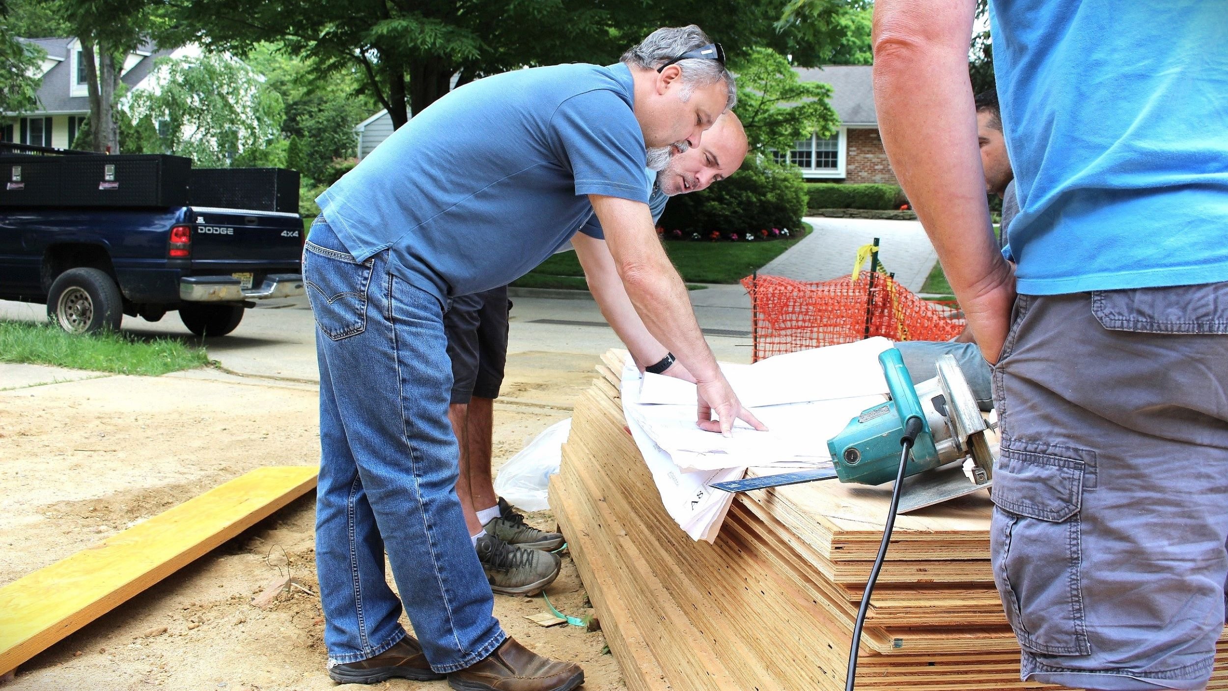 Architect reviewing residential construction drawings with contractors on-site during custom home construction in Moorestown, New Jersey