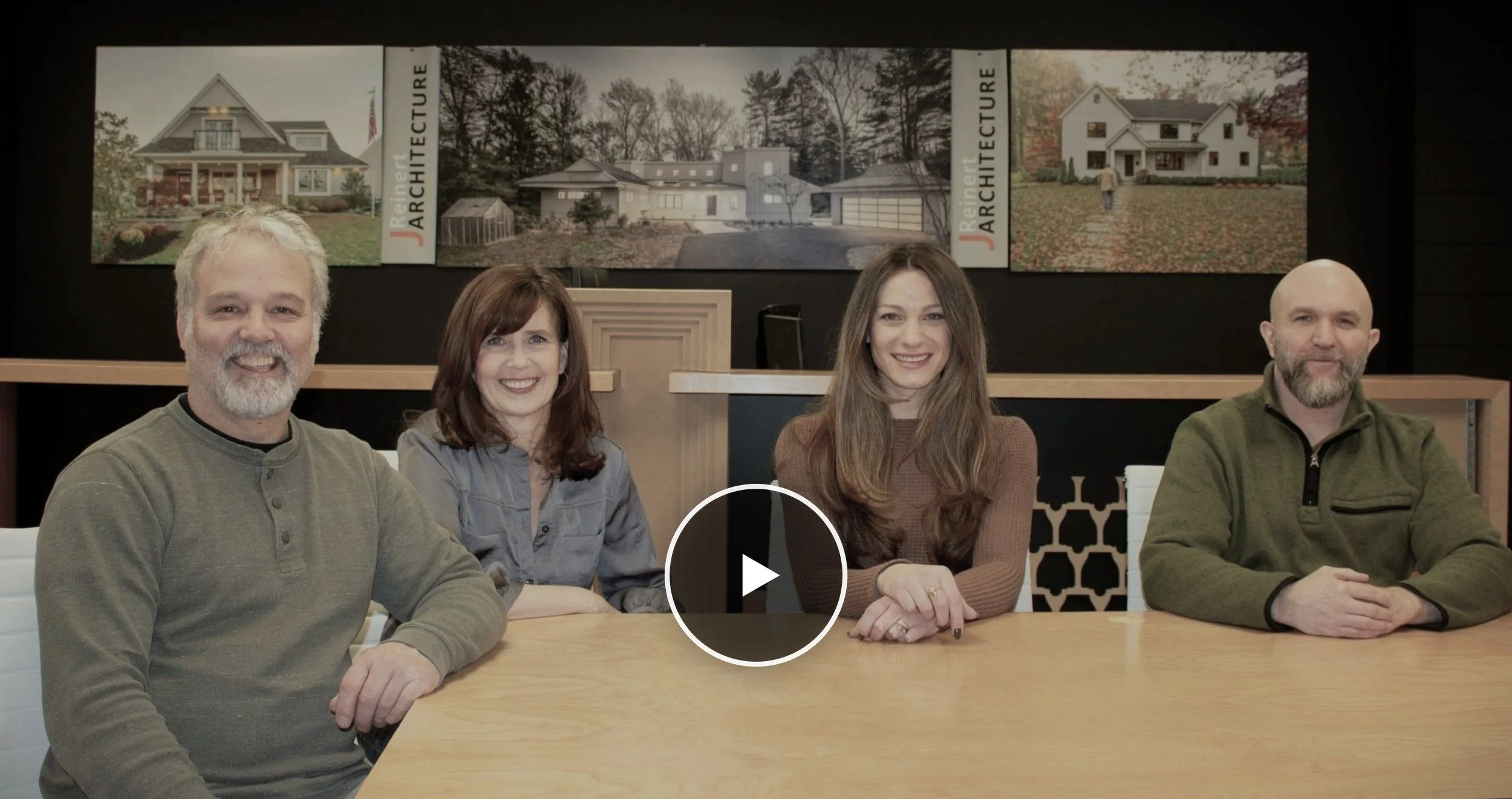 The J Reinert Architecture team — Jay Reinert, Emily Manera, Steve Okulewicz, and Nancy Repsher — seated in the Haddonfield, NJ studio. Play button links to the firm's studio film.