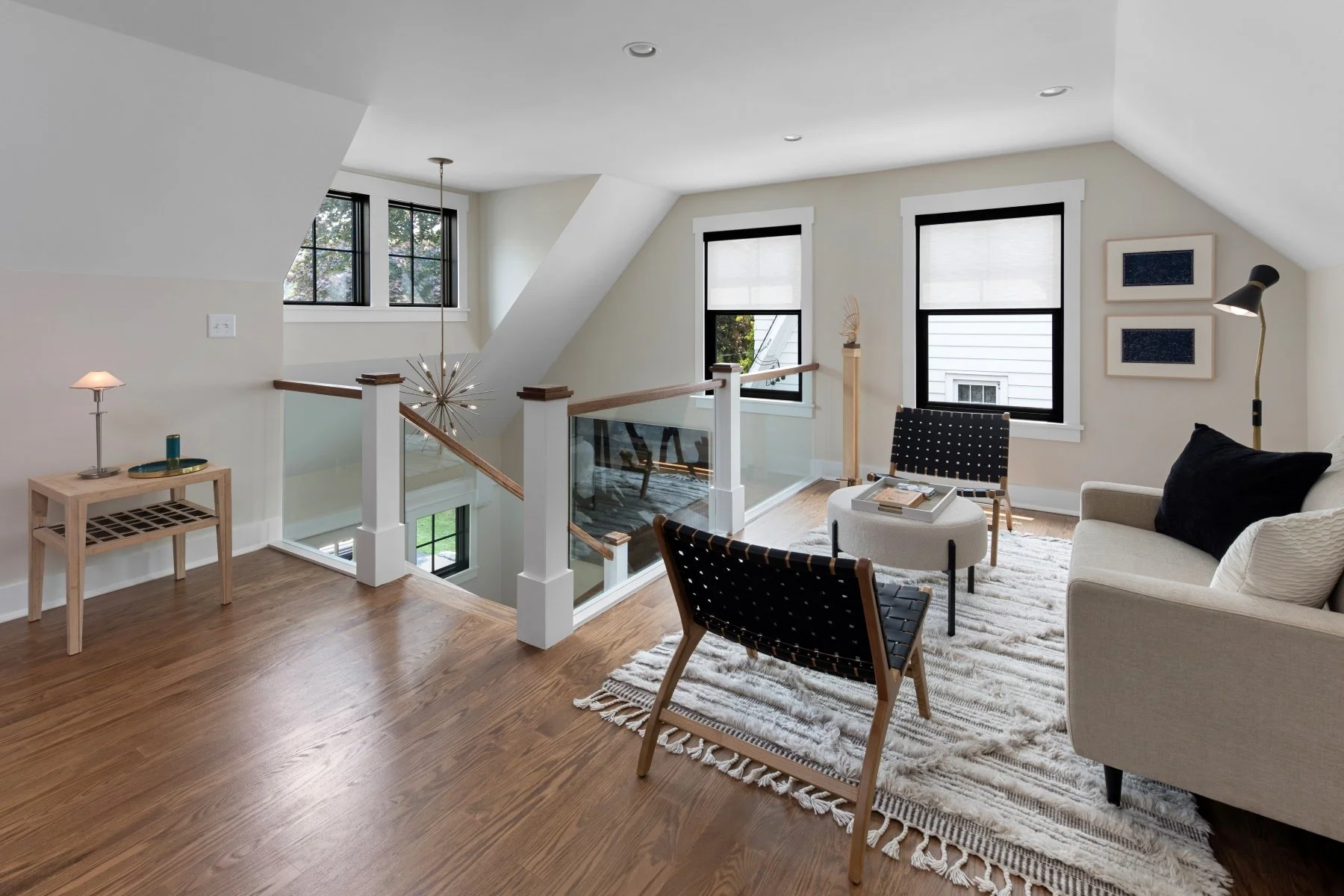 Second-floor loft with glass railing in Artfully Done contemporary Craftsman renovation in Haddon Heights, NJ, designed to display art and connect visually to the first floor.
