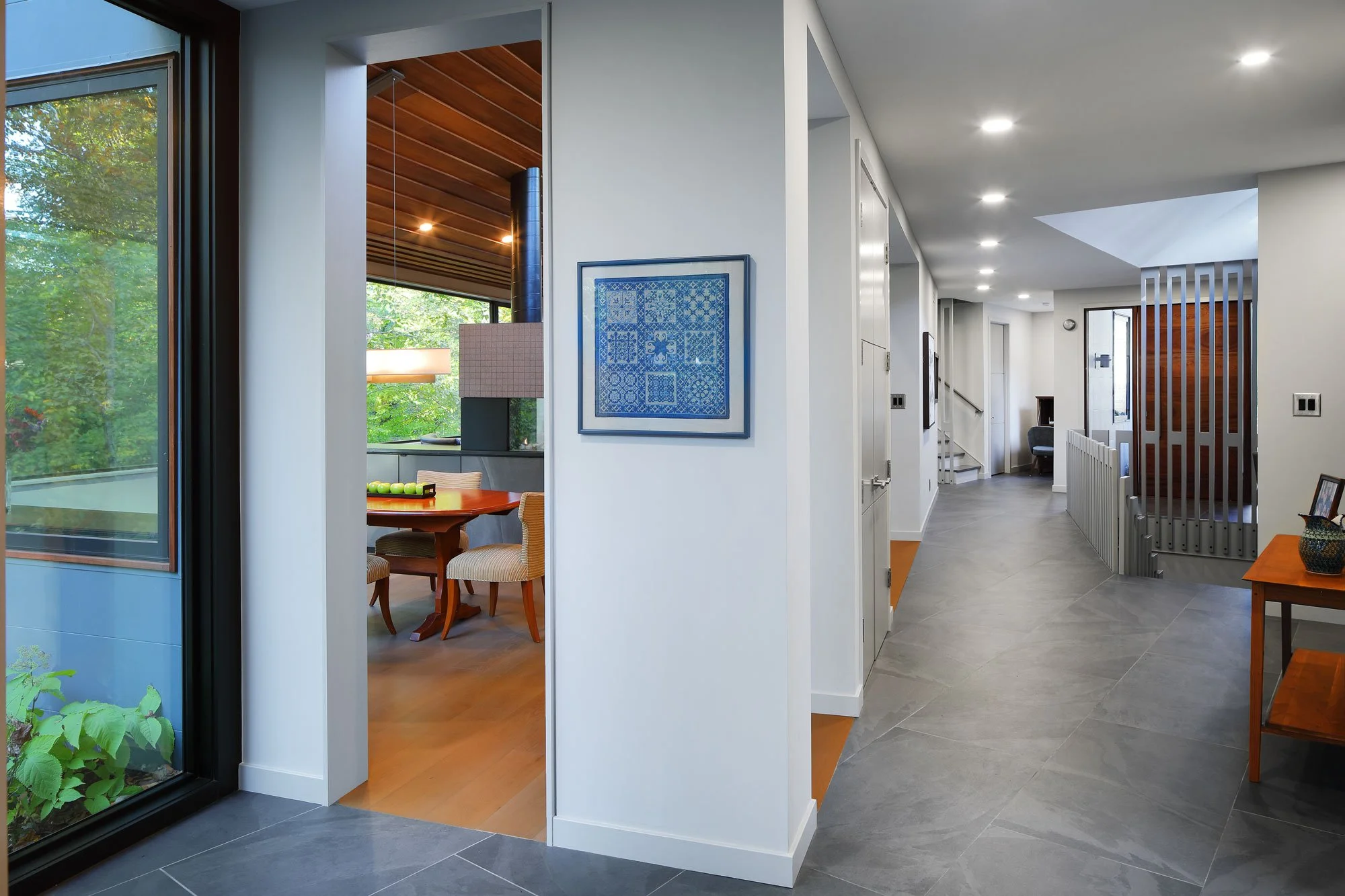 The ligament at Hadro House Haddonfield NJ — the continuous circulation spine connecting the home's volumes, with views opening to the dining room and landscape beyond