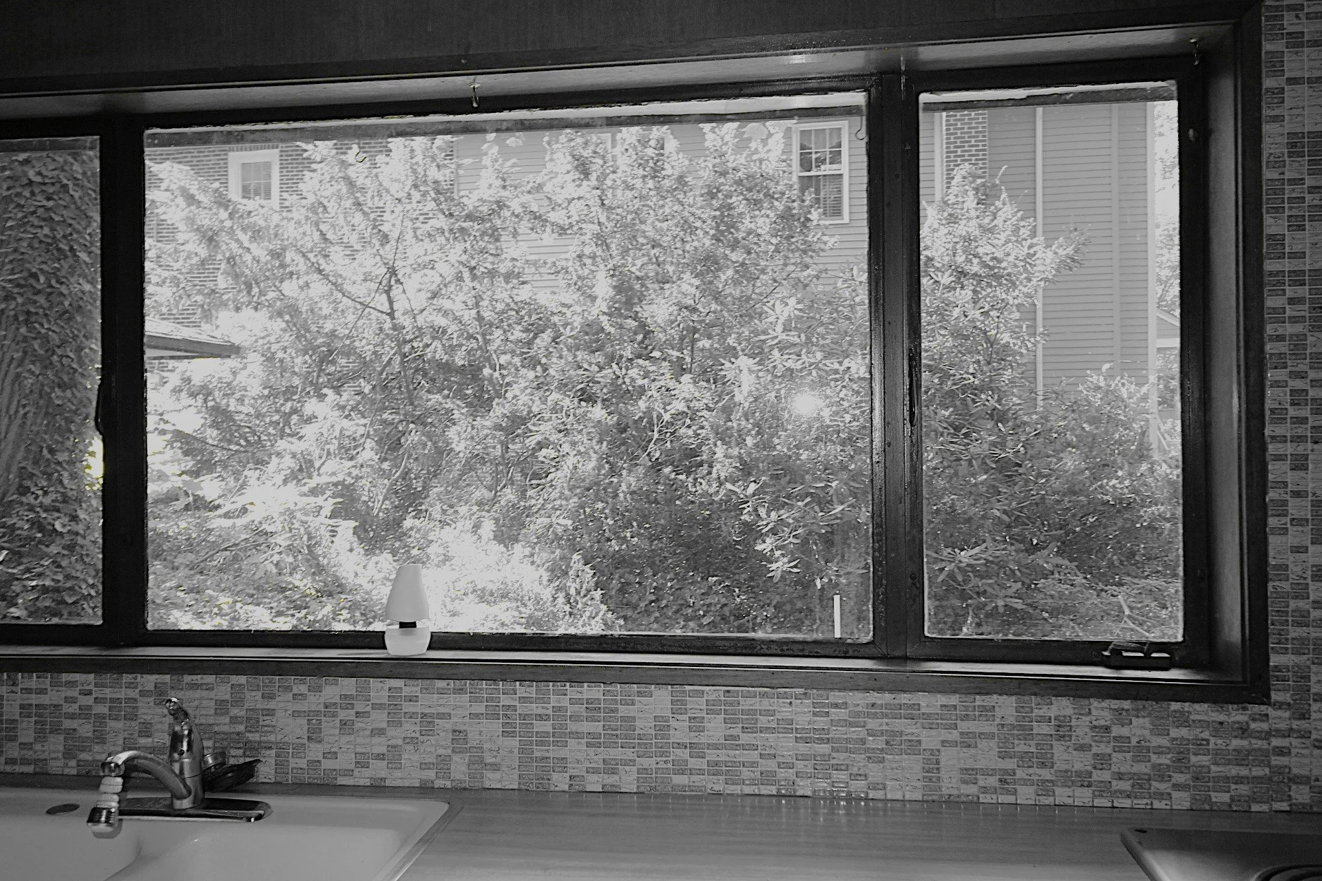 Kitchen window of the original mid-century home on the Hadro House site, Haddonfield NJ — the connection to the woods that the new design would inherit and amplify