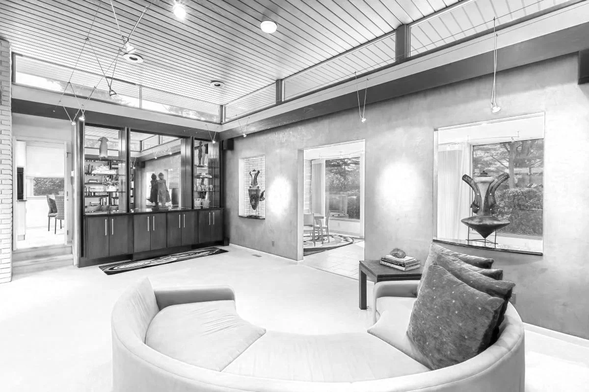 Before photo of a Cherry Hill, NJ mid-century modern living room with red accent wall, clerestory windows, wood ceiling, built-in display cabinetry, and open interior connections.