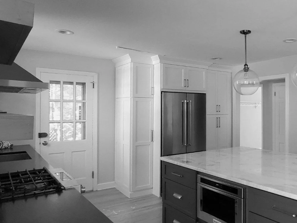 Before photo of the kitchen in a Haddonfield, NJ center hall colonial renovation showing the existing island, cabinetry, side entry door, and disconnected family circulation before redesign.