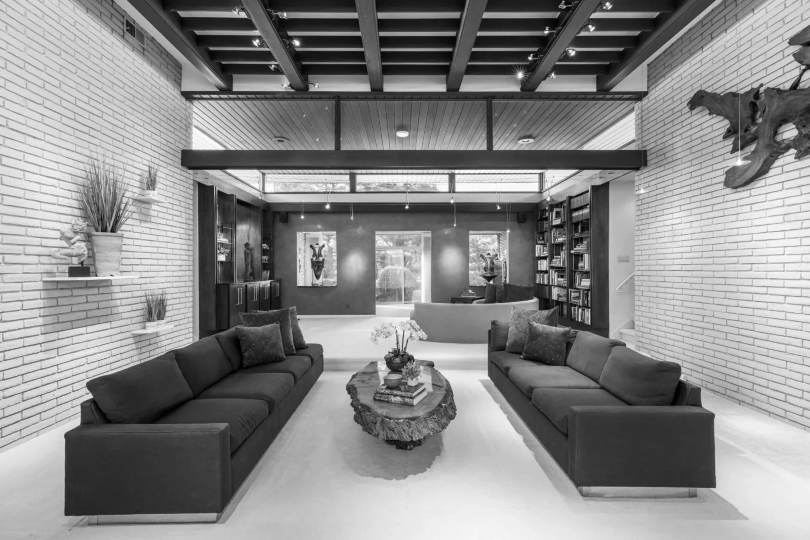 Before renovation living room mid-century modern home Cherry Hill NJ — original structural ceiling clerestory windows white brick red accent wall white tile floor single step level changes sitting area 1964
