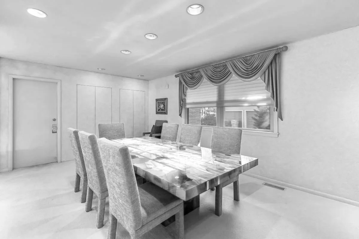 Before photo of the dining room in a Cherry Hill, NJ mid-century modern home before renovation, showing dated finishes, carpet, drapery, and an enclosed room layout.