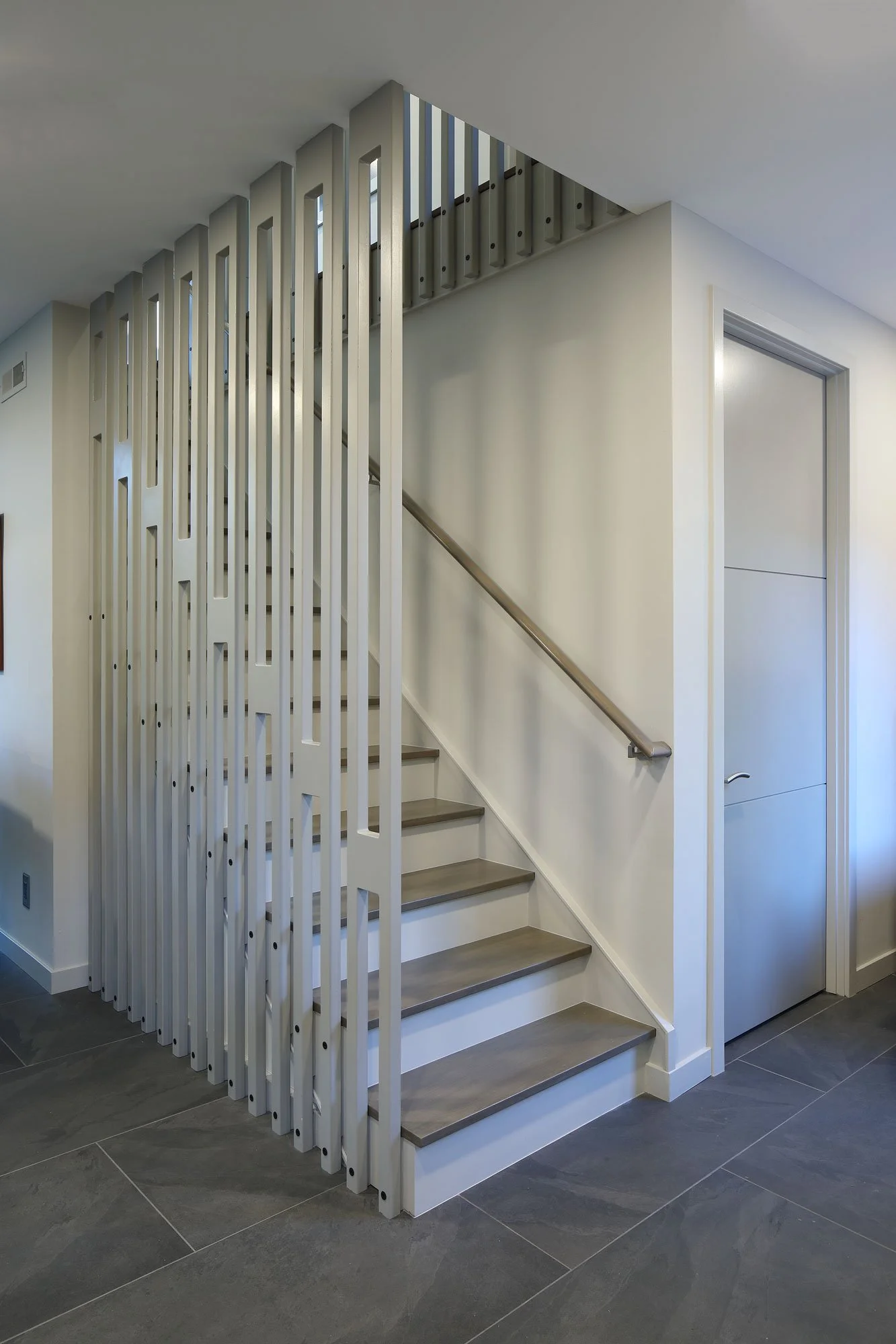 Finished CNC-cut sculptural stair railing at Hadro House in Haddonfield NJ — fabricated from sheet stock with minimal waste, serving Universal Design and craft simultaneously