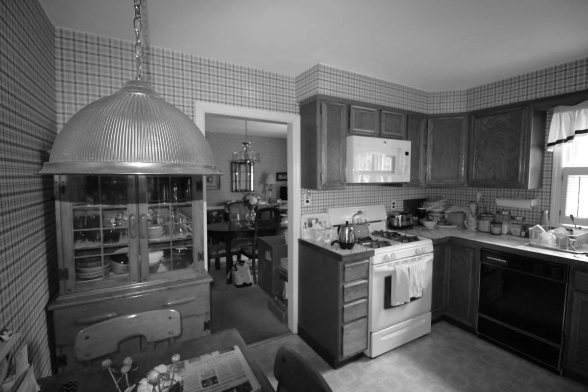 Before renovation — original closed kitchen of cape cod home in Haddon Heights NJ with plaid wallpaper, oak cabinets, and no connection to yard or entry sequence