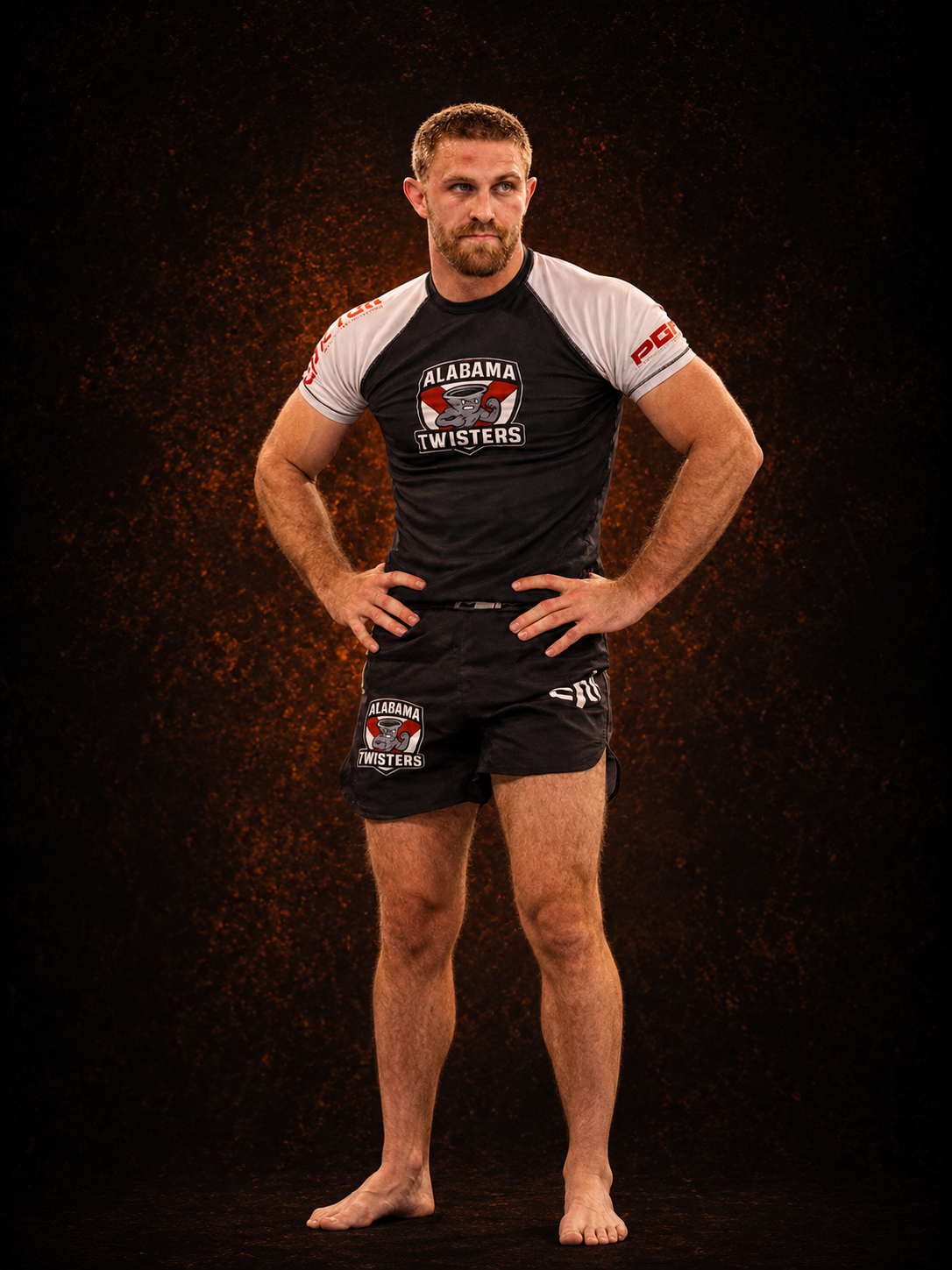 Male athlete standing confidently with hands on hips, wearing black and white sports gear with 'Alabama Twisters' logo, against a dark background with orange accents.
