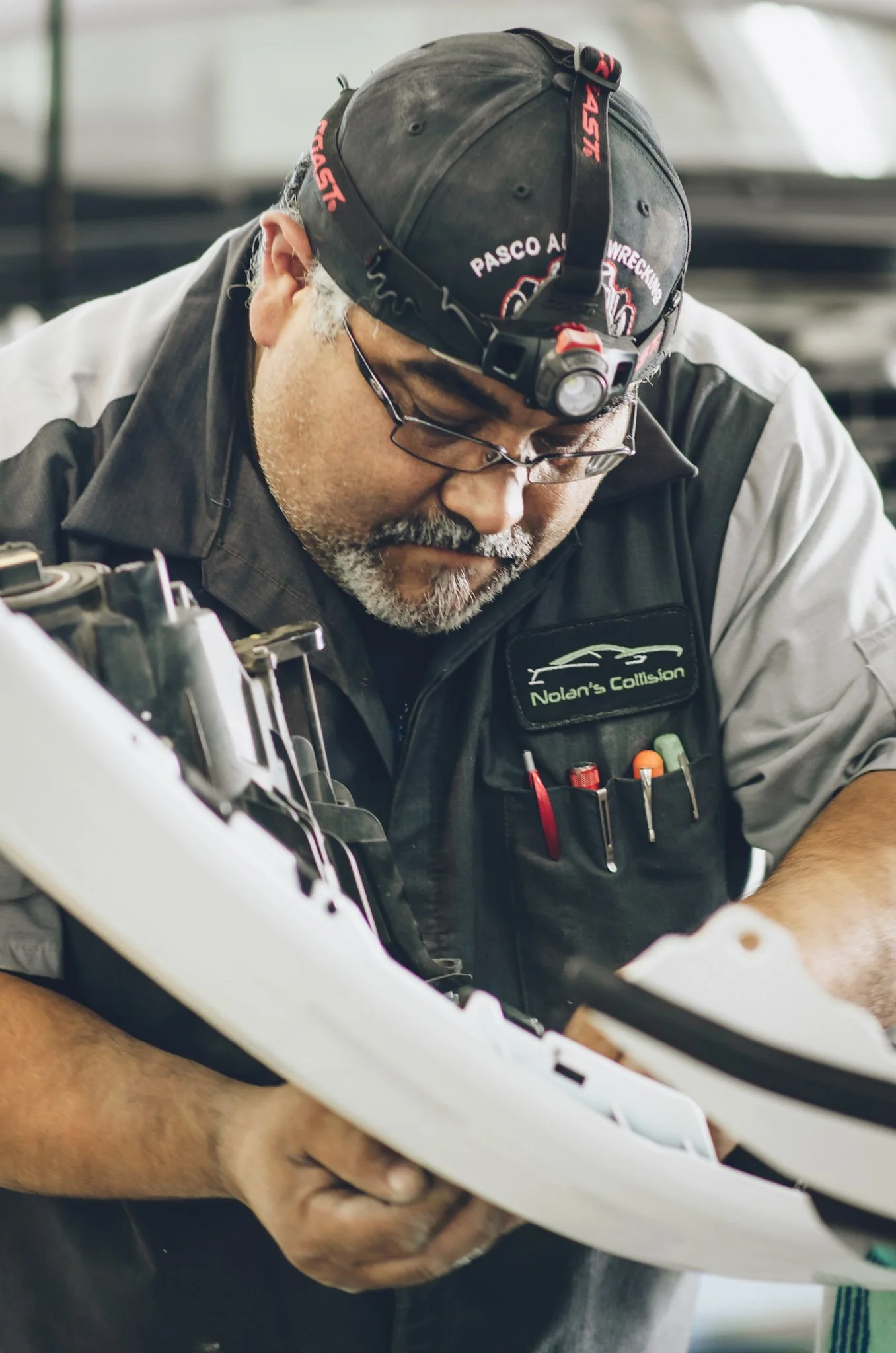 Collision repair technician working on dented car hood