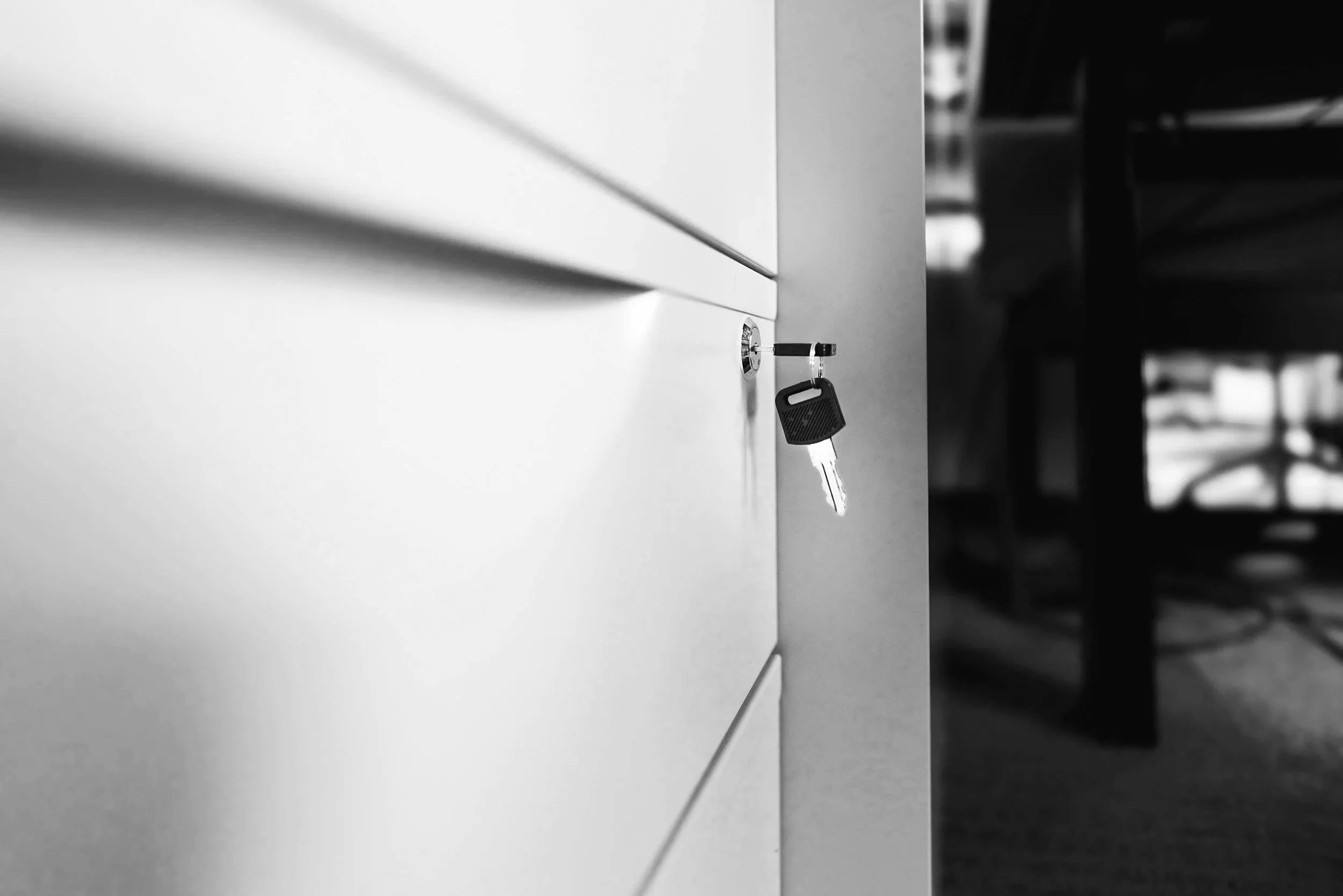 Close-up of a key inserted into a lock on a filing cabinet, representing confidentiality and discretion in legal operations consulting.
