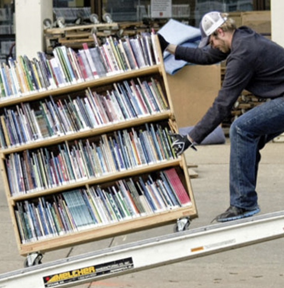 Relocating books to storage on extra large New Haven wood carts.