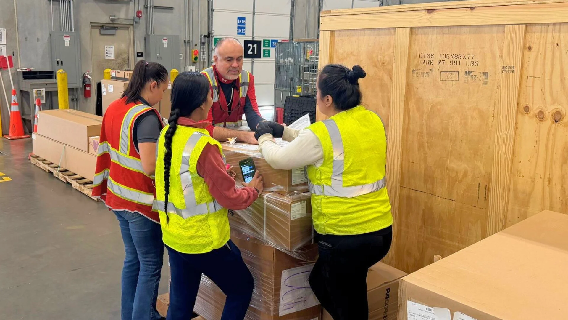 DNA Logistix warehouse associates reviewing a palletized shipment at a national distribution center.