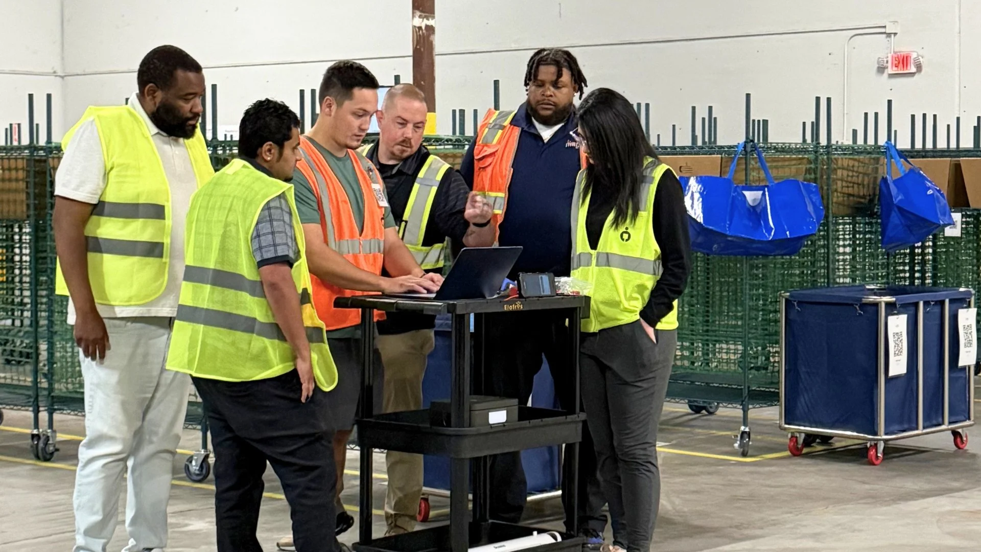 DNA Logistix warehouse team reviewing operational performance metrics at a national distribution facility, demonstrating data-driven warehouse management and continuous improvement.