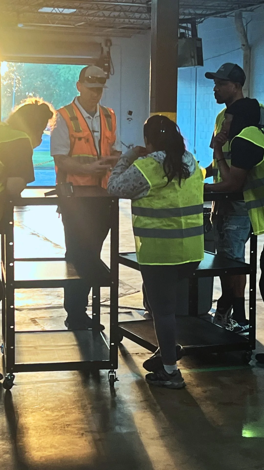 DNA Logistix Norfolk warehouse team and on-site leadership reviewing daily logistics operations at the Virginia headquarters, reflecting the company's people-first 3PL culture and loading-dock-up leadership approach.