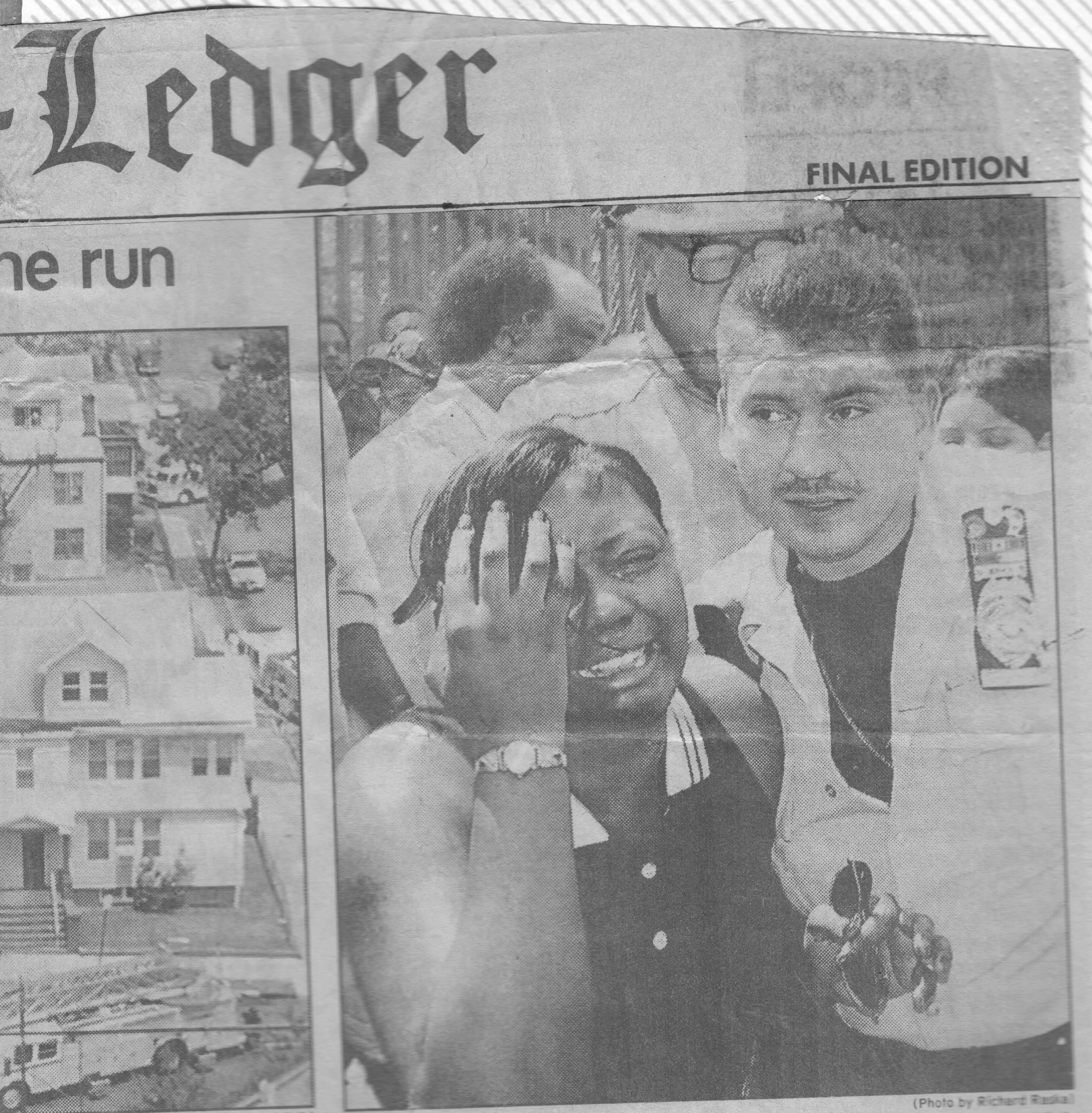 Black and white newspaper with a photo of a young woman holding a gun to her temple, smiling, with the headline 'Leopard' and 'Final Edition,' and partial images of houses and trees.