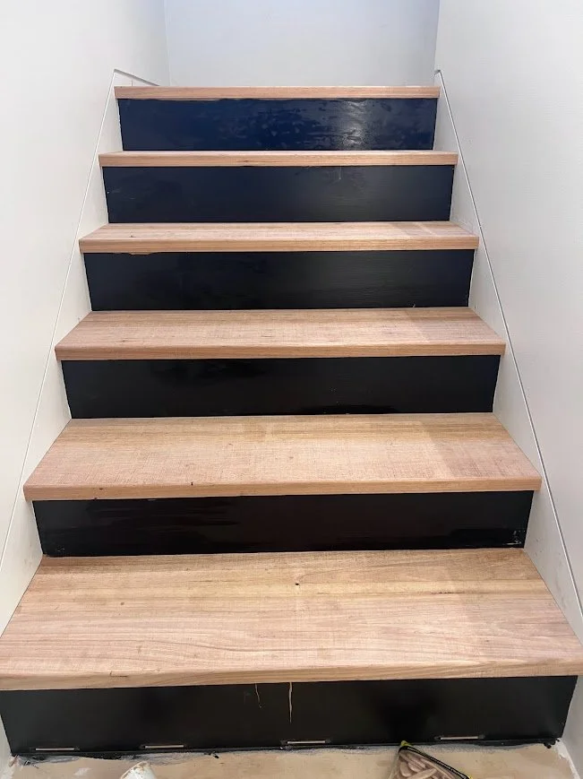 Staircase with wooden treads and black painted risers