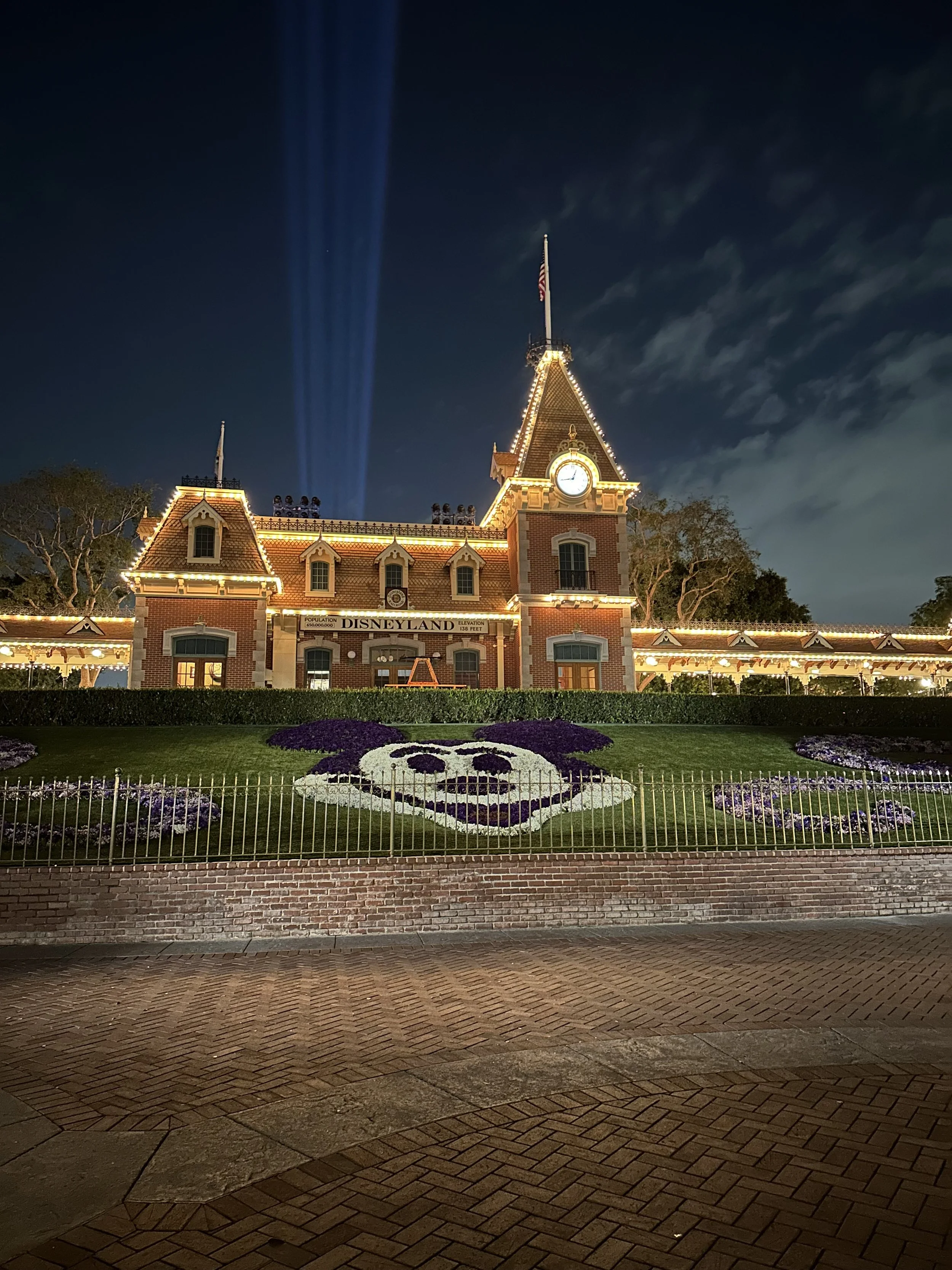 disneyland-train-station-at-night-lit-up-spot-lights-behind-the-train-station