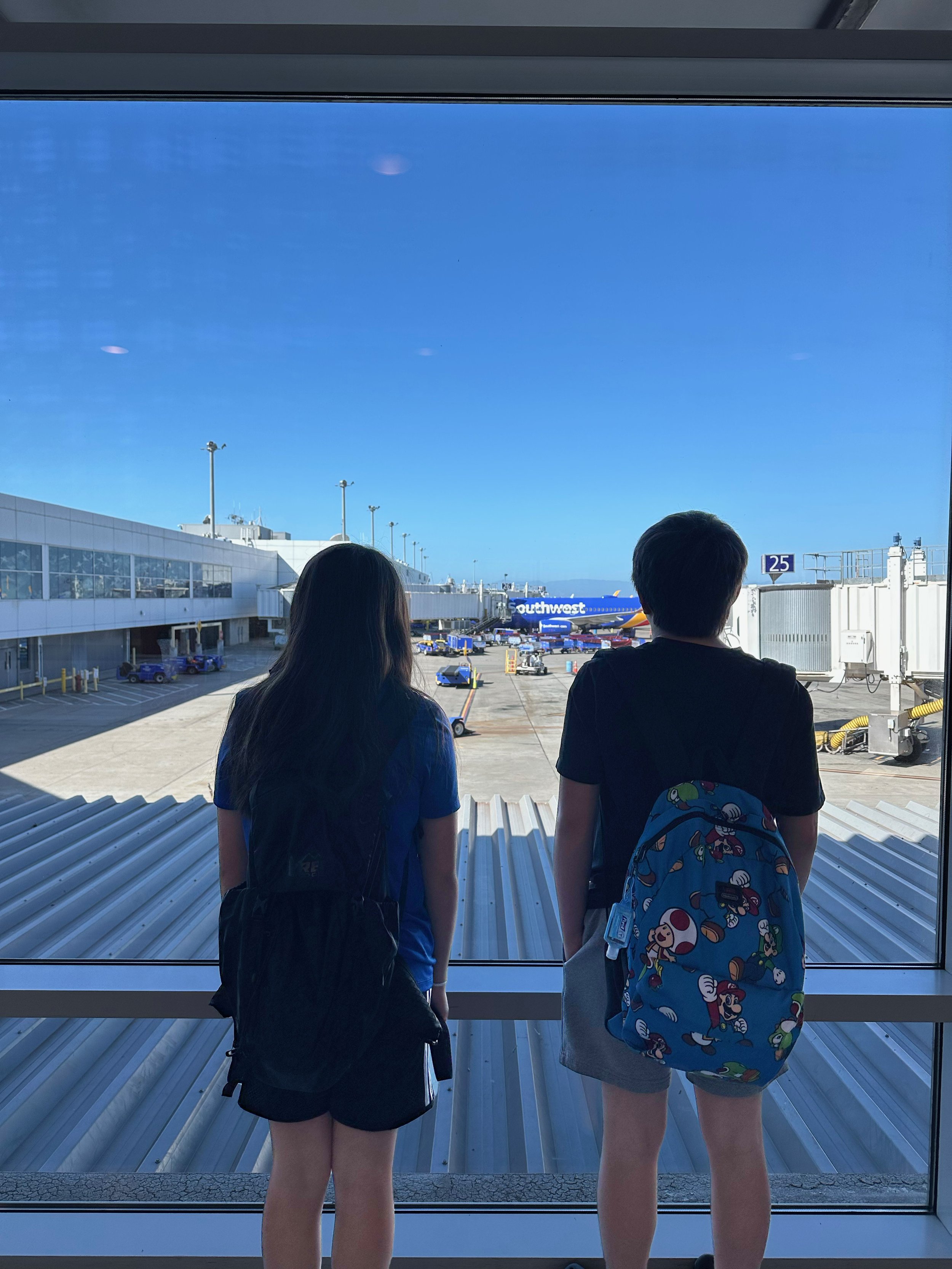 my-two-kids-at-the-oakland-airport-looking-out-the-window-at-southwest-airplane
