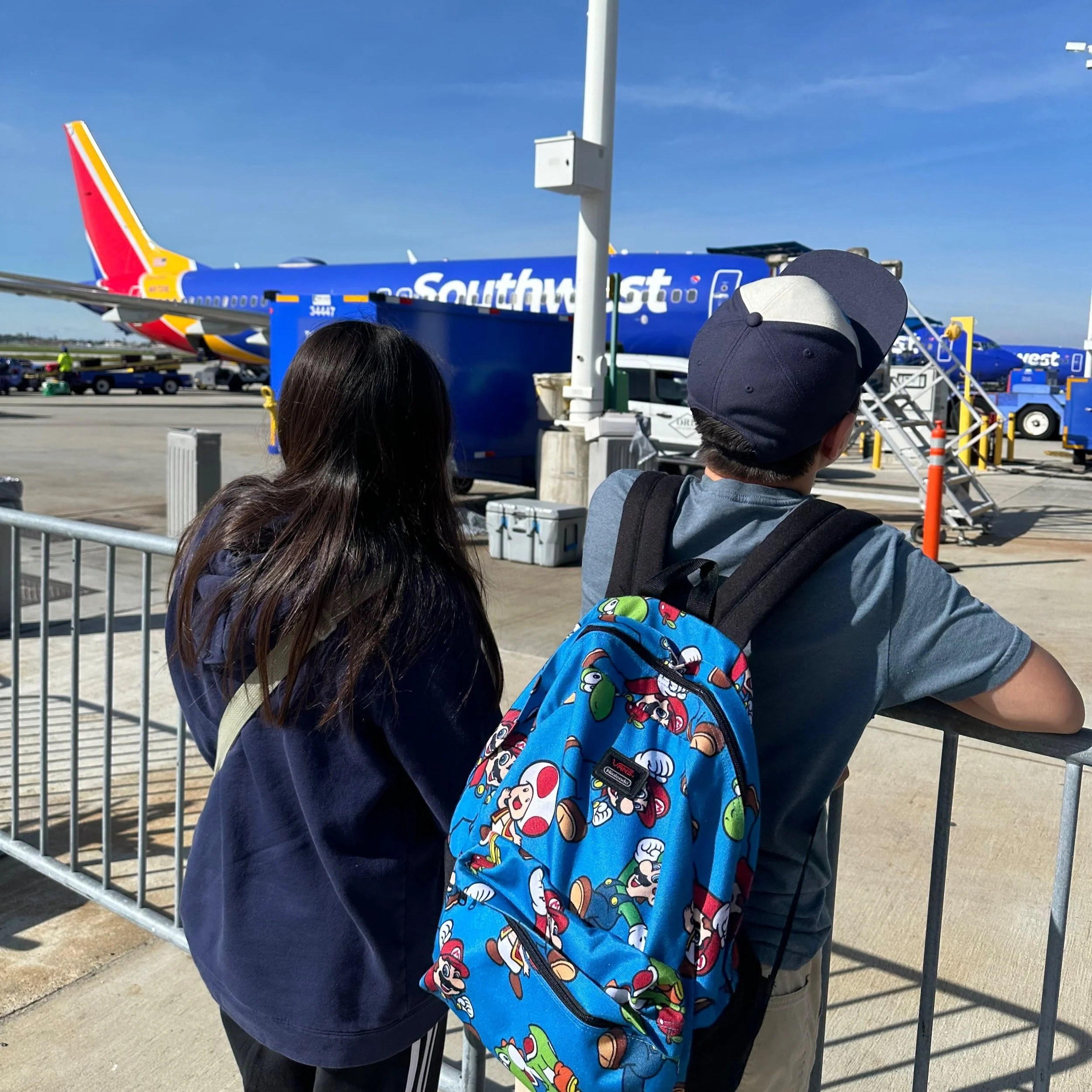two-kids-boy-and-girl-looking-at-a-southwest-plane-at-the-long-beach-airport-on-a-sunny-day