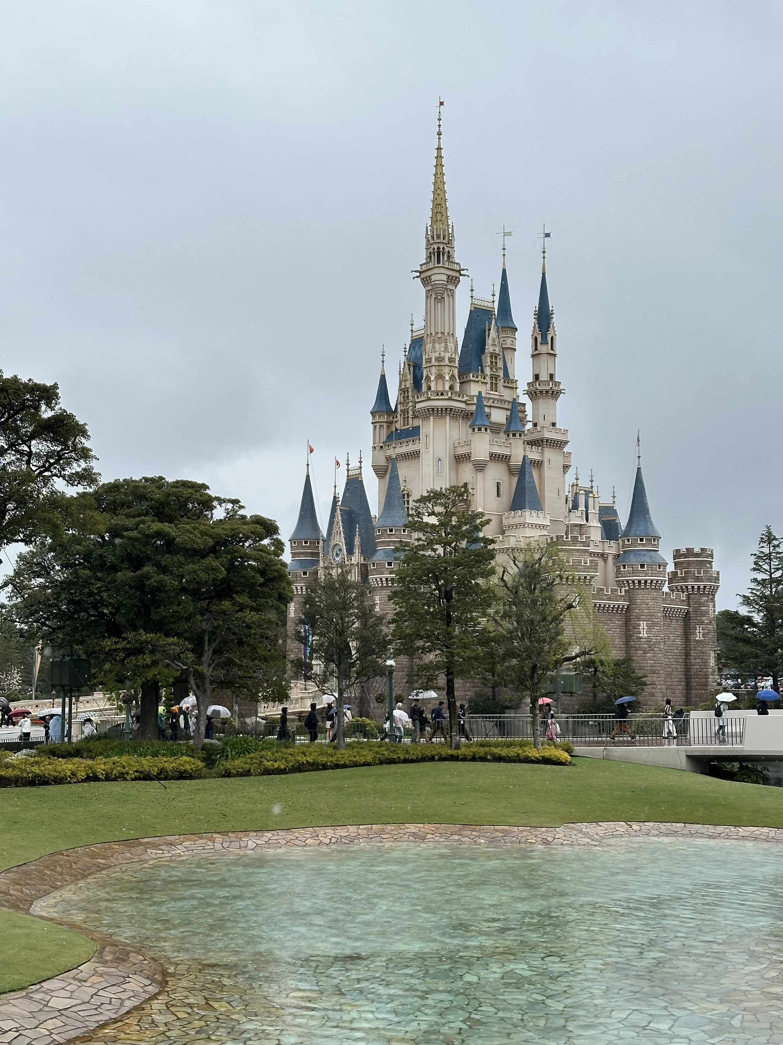 sleeping-beautys-castle-at-tokyo-disneyland-with-people-walking-on-a-cloudy-day