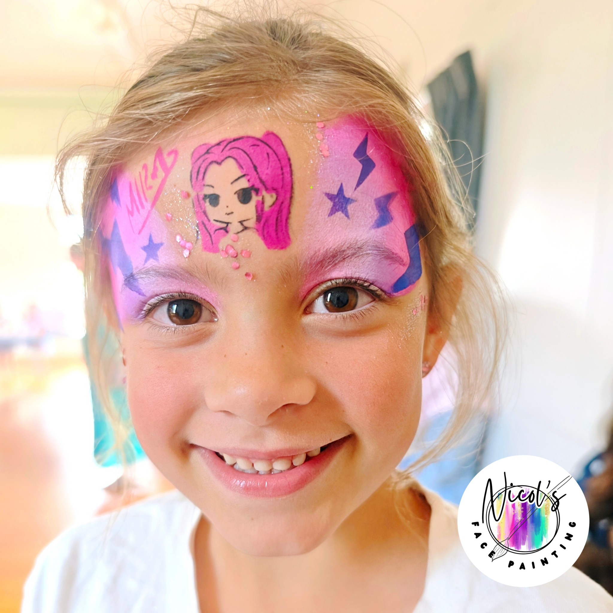 Close-up of a person's face with colorful face paint and glitter, featuring a cartoon girl with purple hair, purple stars, and pink accents on the forehead, smiling with visible teeth.