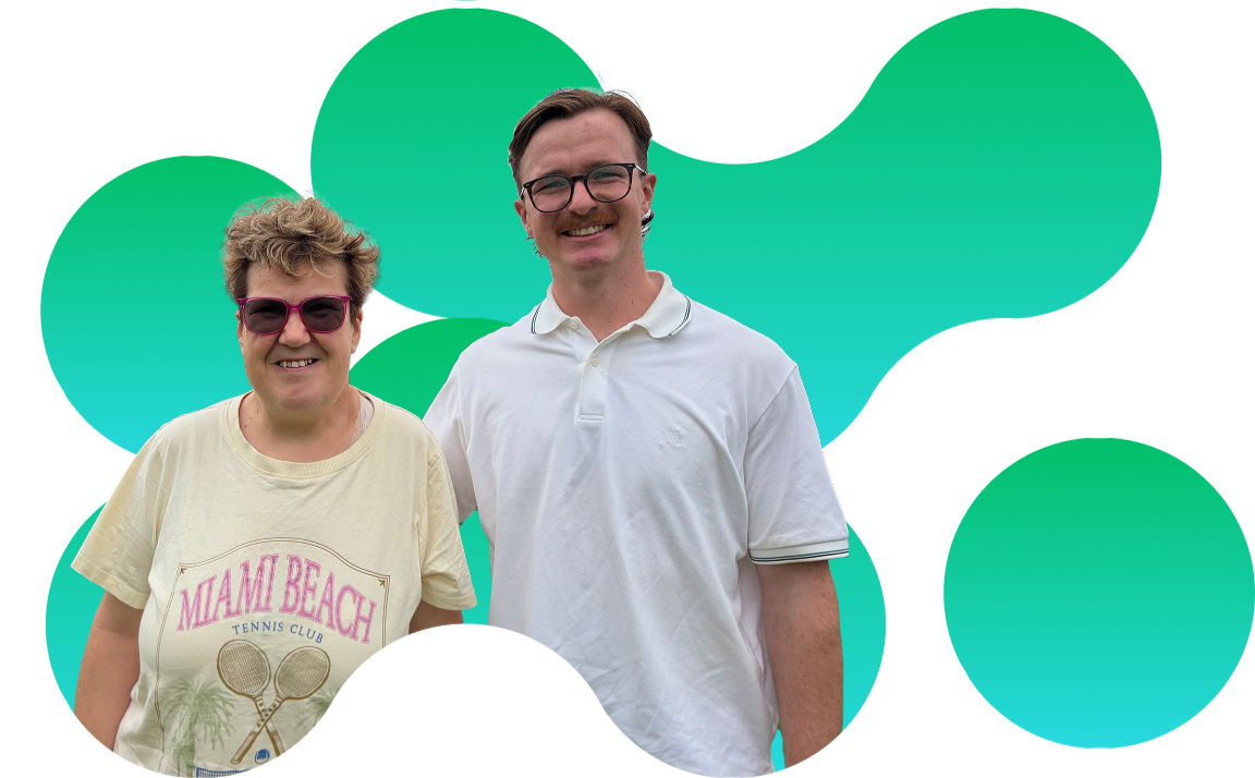 A smiling woman wearing pink sunglasses and a cream Miami Beach tennis club t-shirt standing next to a smiling man in glasses and a white polo shirt.
