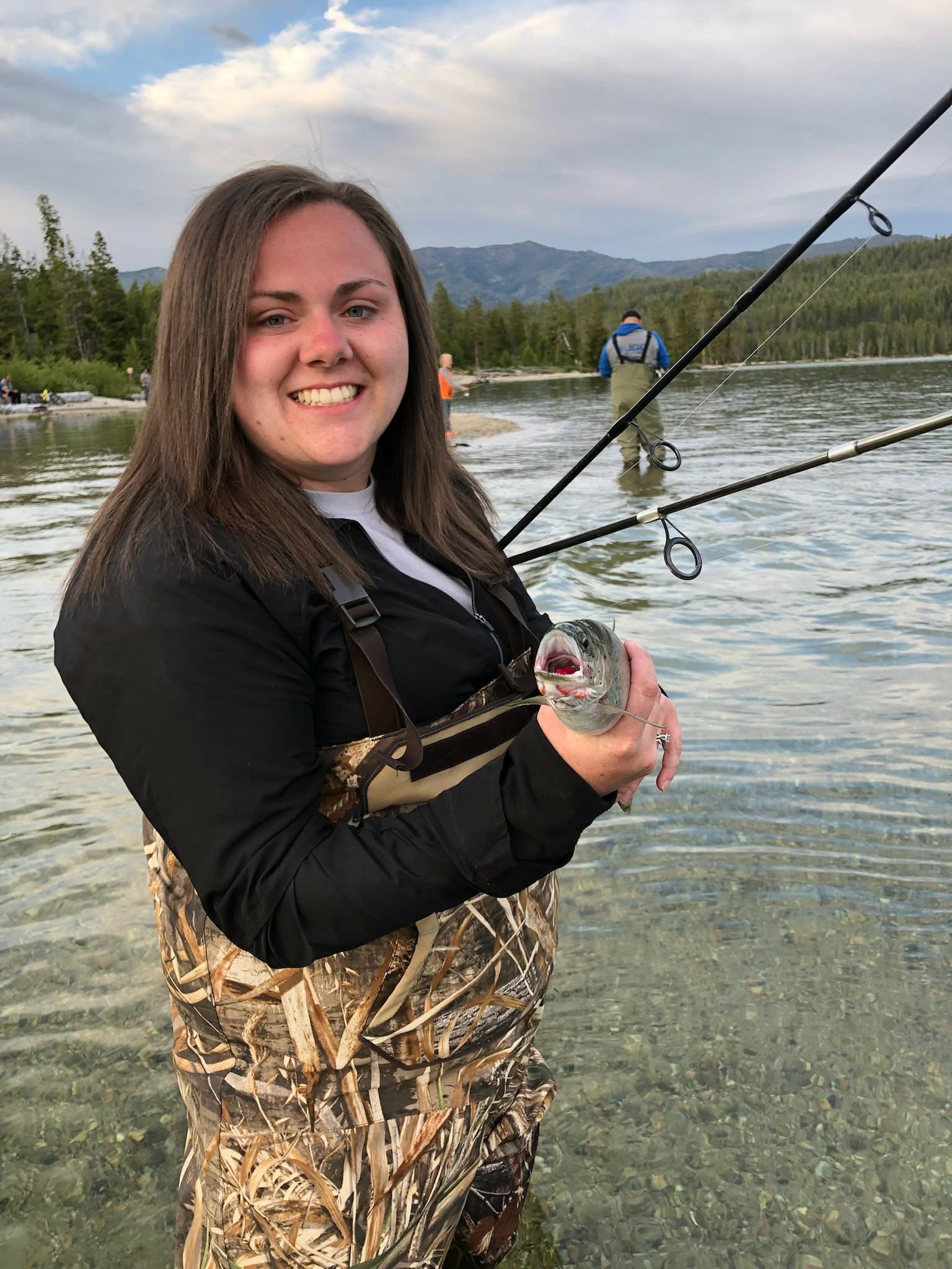 Angler holding a fish beside a mountain lake in Idaho representing the outdoor lifestyle behind Dilly Dahle Custom Rods.