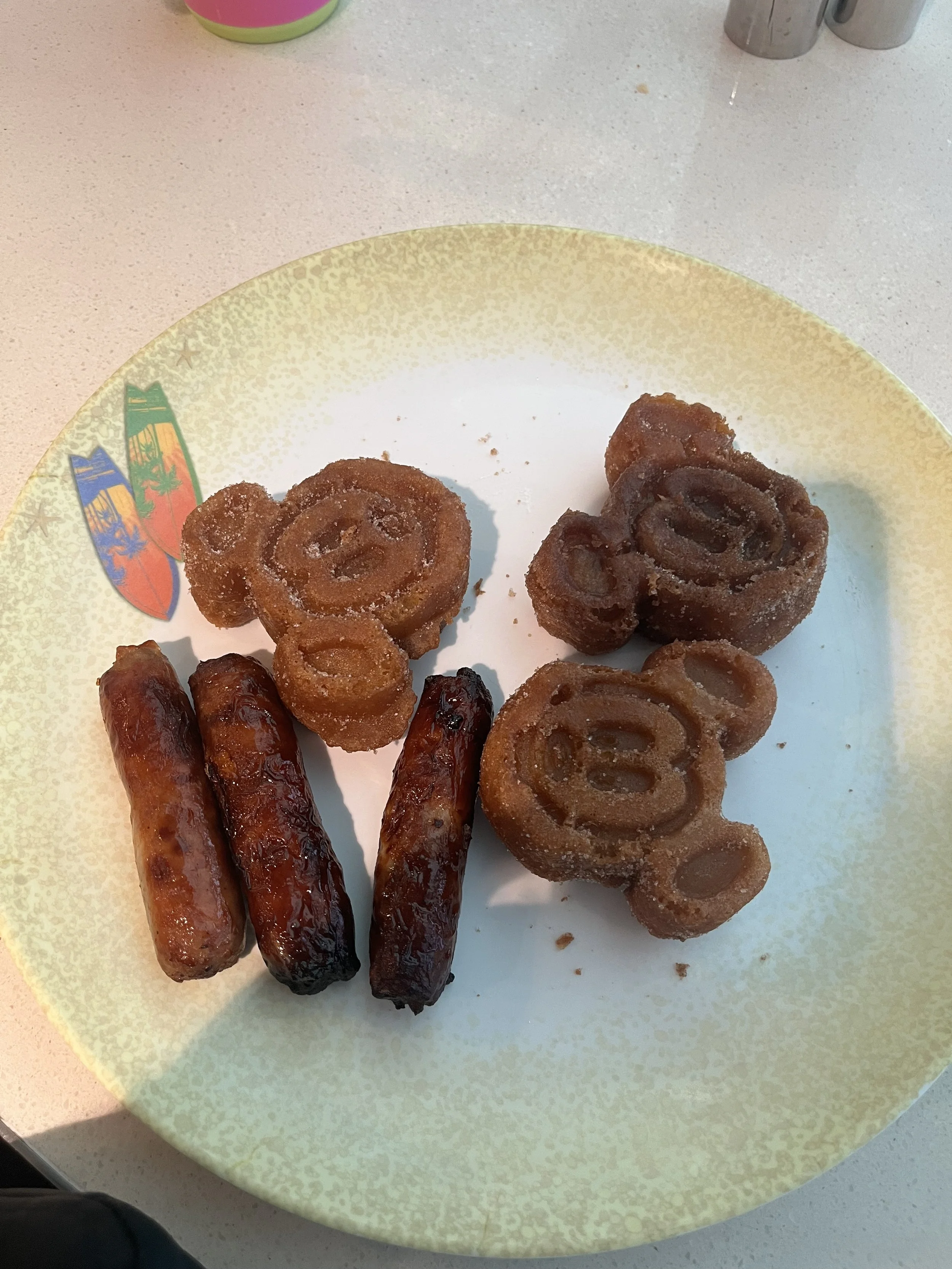 mickey shaped waffles covered in cinnamon sugar. 3 pork sausage links