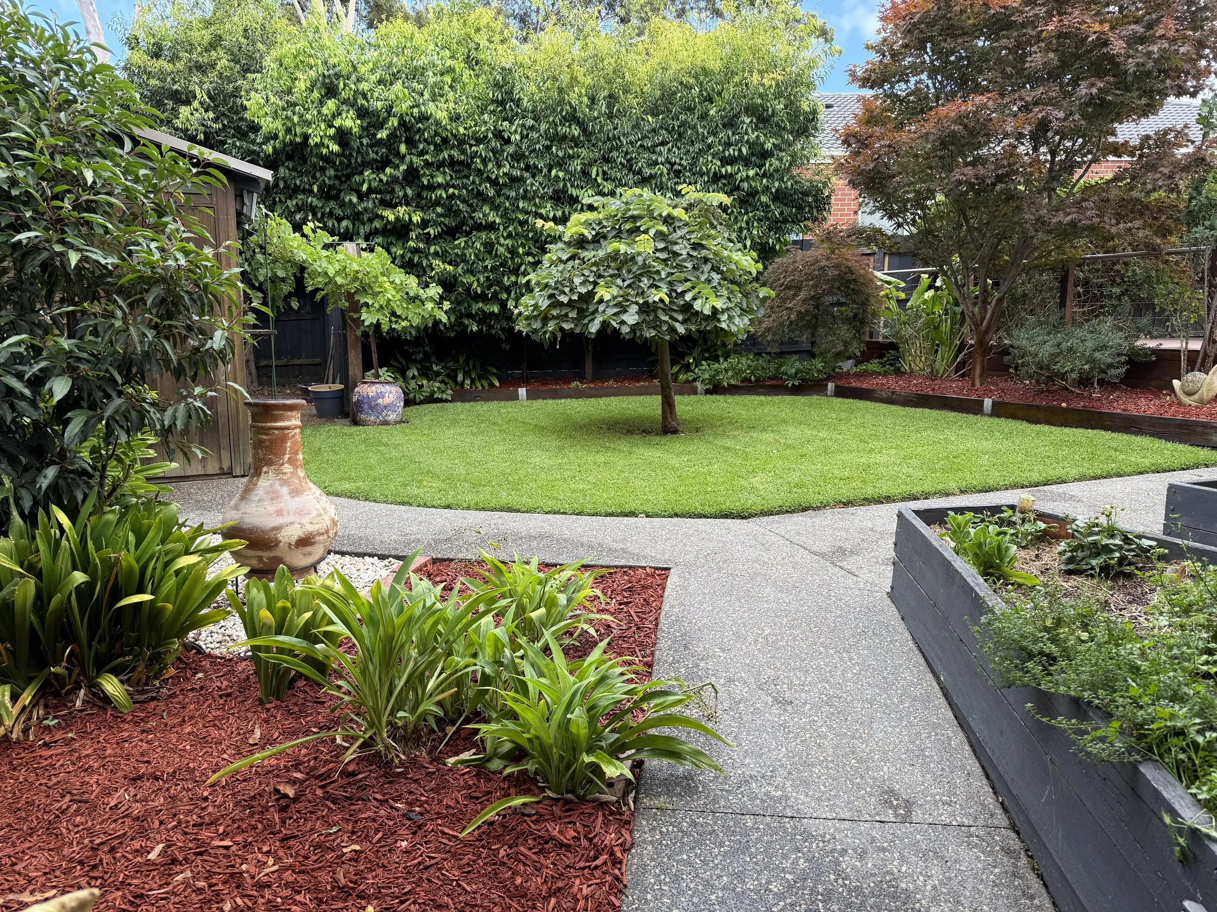 Freshly barked garden beds and mown lawn at a Vermont South property prepped for sale