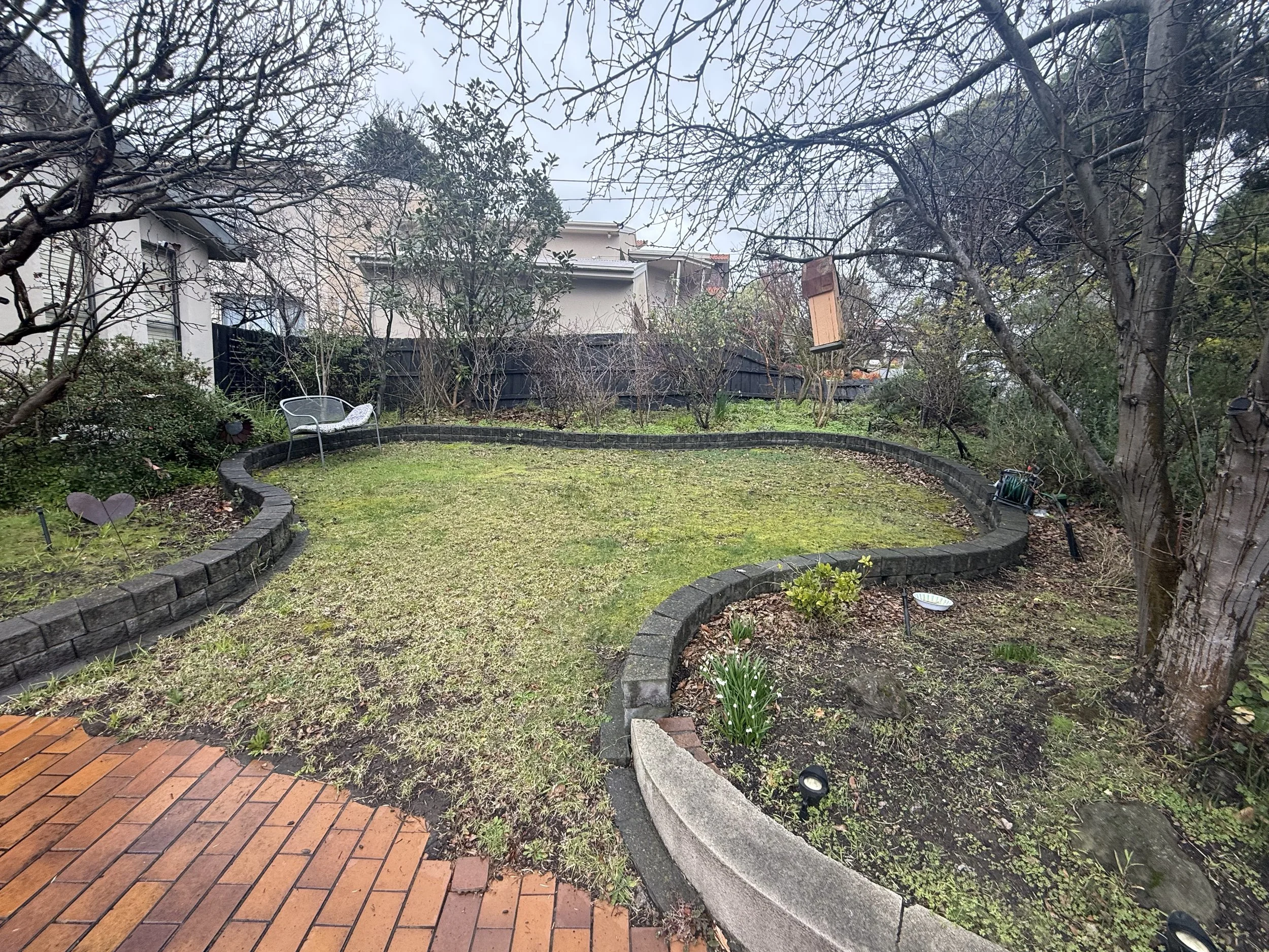 Patchy front lawn and untidy garden beds before a pre-sale garden tidy-up in Vermont South
