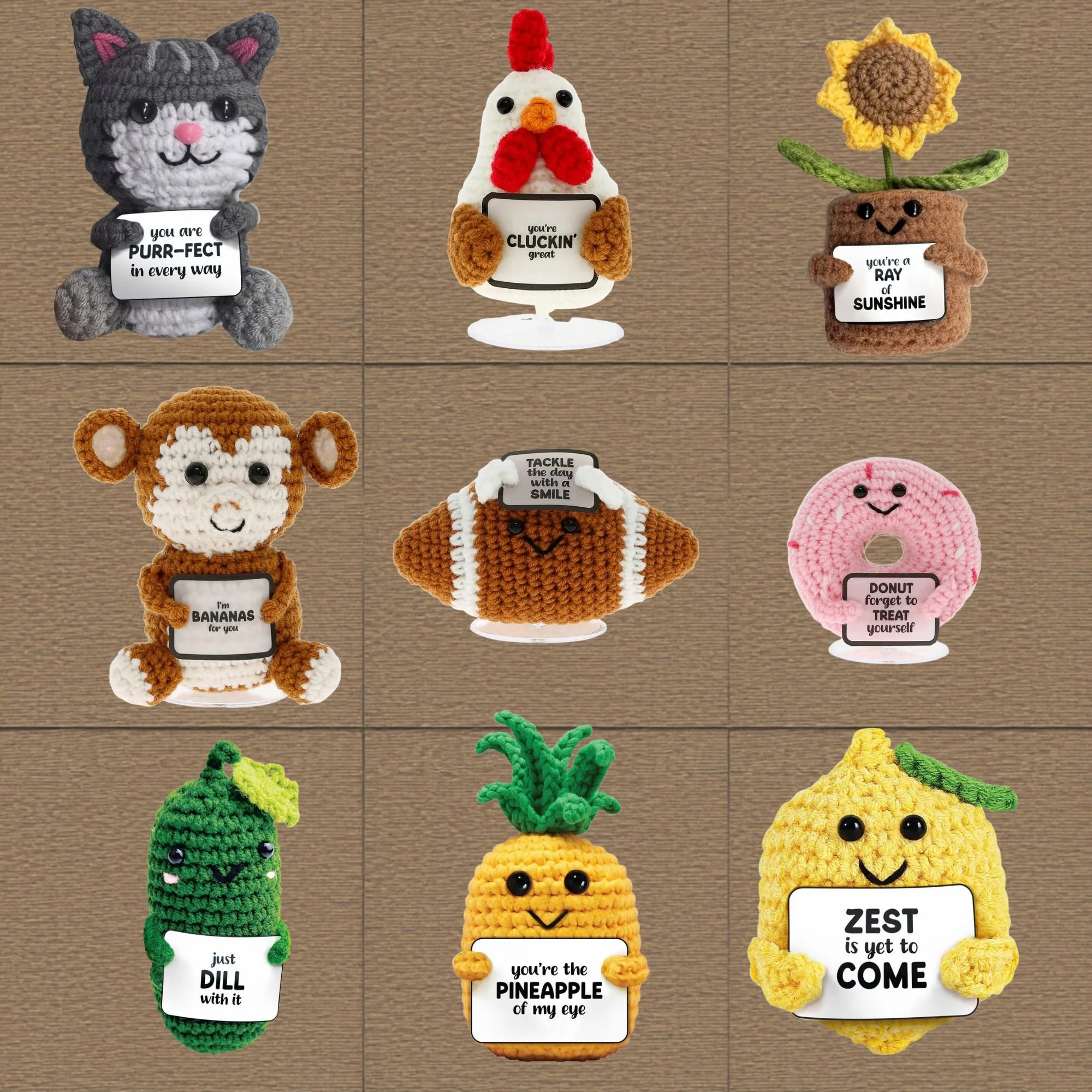 Crochet plush toys shaped like animals and objects with humorous messages. From left to right: a gray cat holding a sign saying 'you are PURR-FECT in every way', a white chicken with red comb and wattles holding a sign saying 'you're CLUCKIN' great', a brown planter-shaped plush with a sunflower and a sign saying 'you're a RAY of SUNSHINE', a brown monkey holding a sign saying 'I'm BANANAS for you', a yellow pineapple holding a sign saying 'you're the PINEAPPLE of my eye', and a yellow chick with a sign saying 'ZEST is yet to come'.