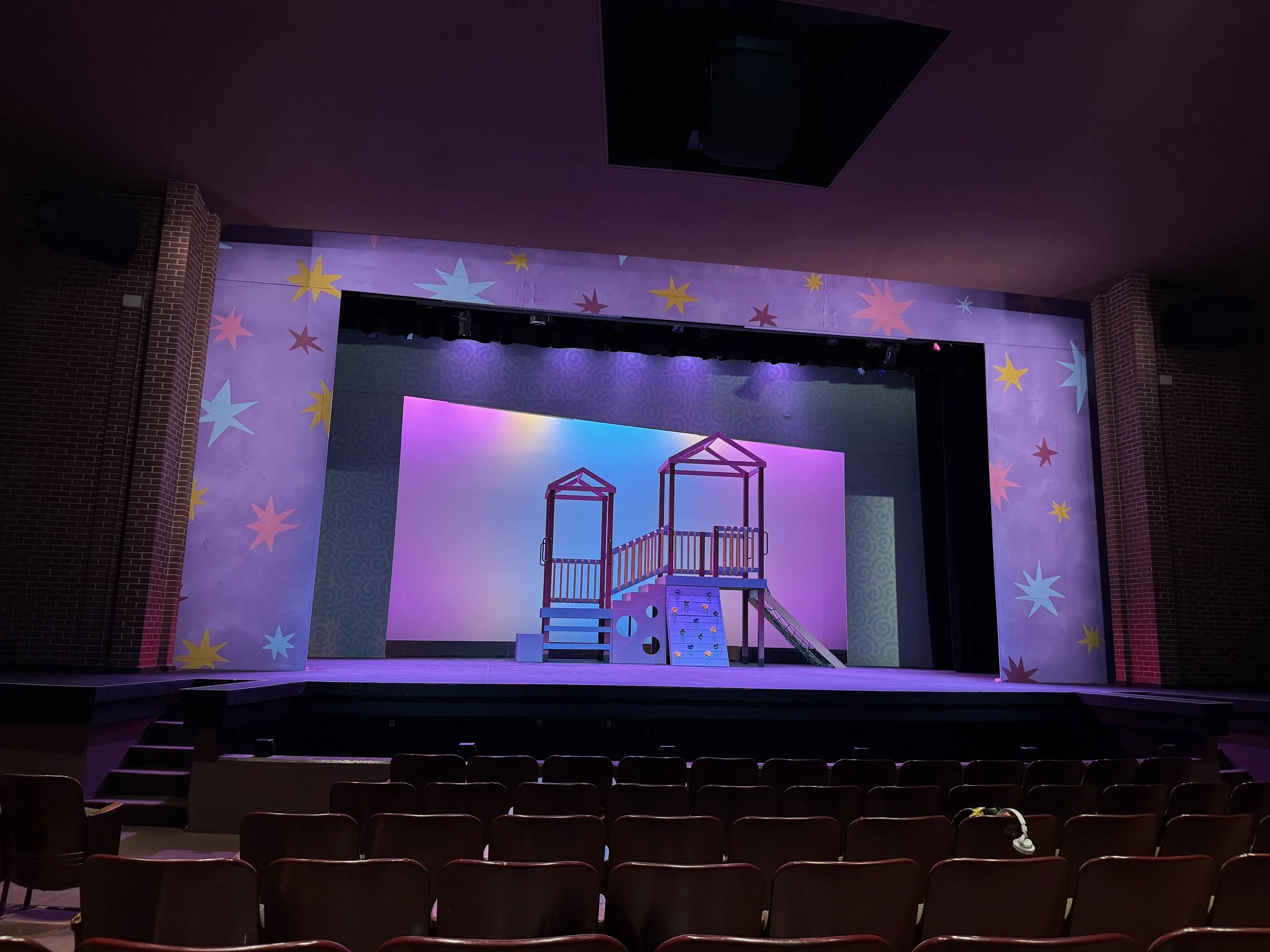Stage set with colorful backdrops, stage props, and lighting for a children's performance or play.