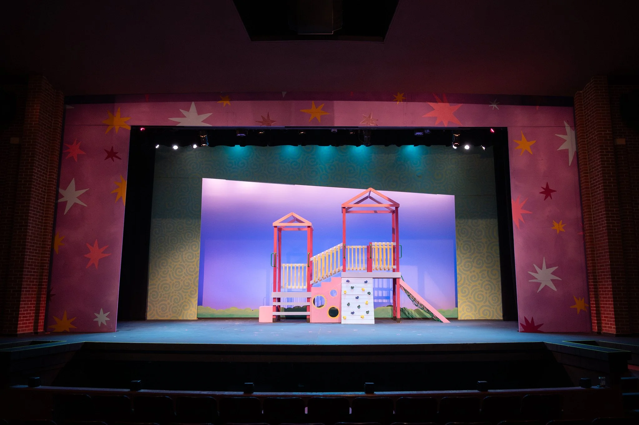 Stage set with colorful backdrops, stage props, and lighting for a children's performance or play.