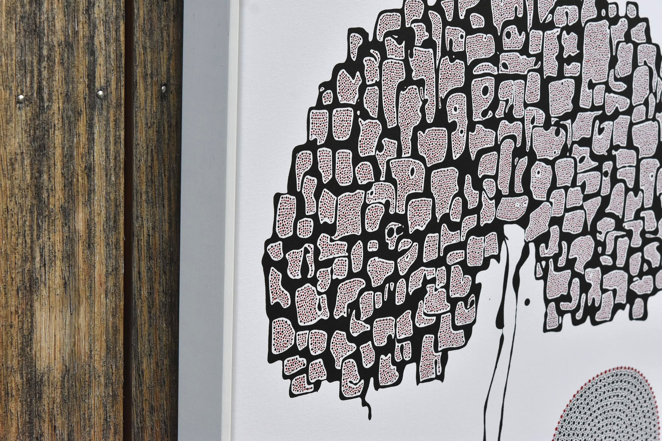 An abstract black outline shaped like a human brain filled with red and white dots on a white wall. Julian Oates