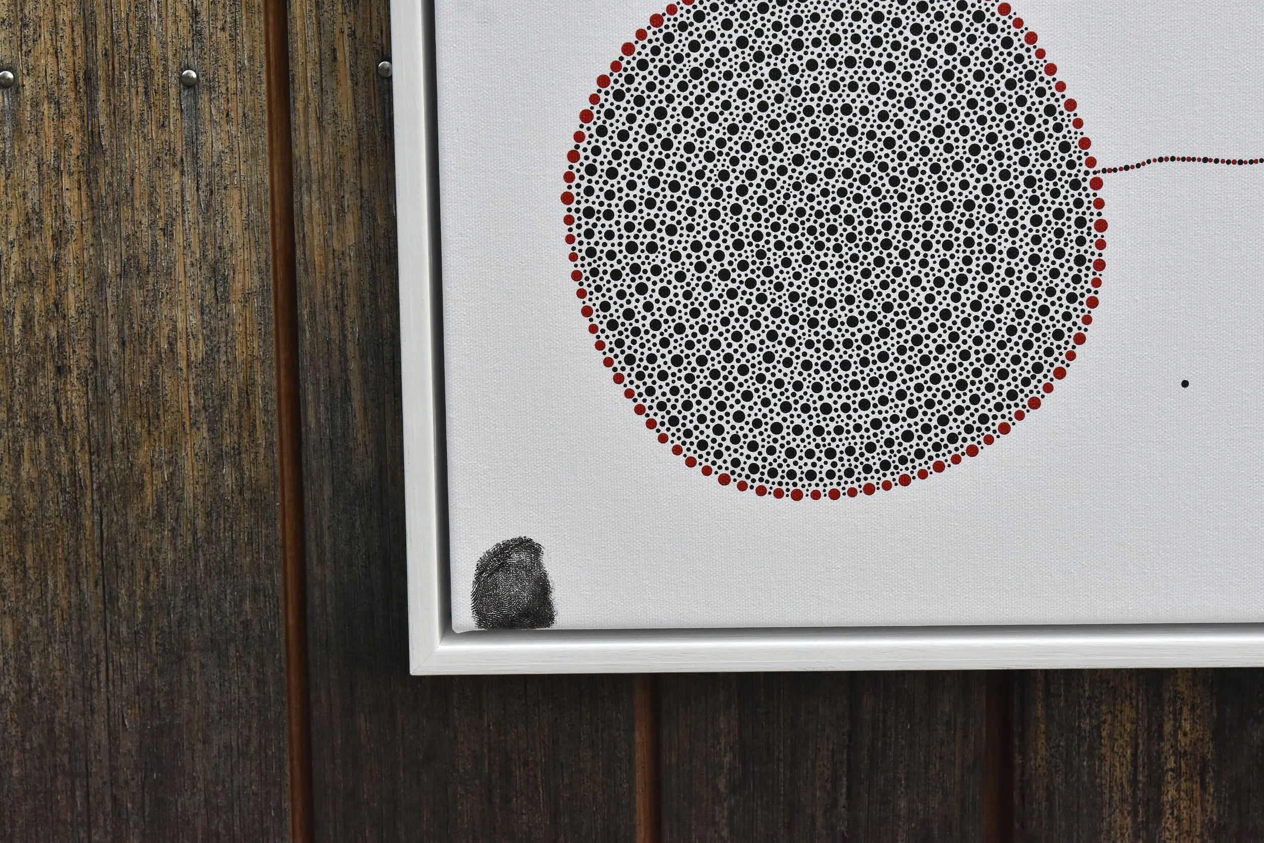 Close-up photo of a fingerprint at the bottom of a geometric dot pattern that resembles a ladybug, on a white background. Julian Oates